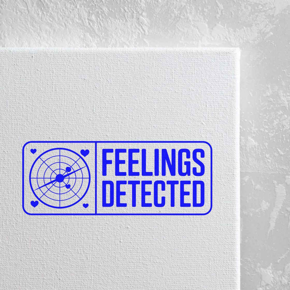 Blue FEELINGS DETECTED stamp seal with radar circle and heart icons on a white textured canvas.