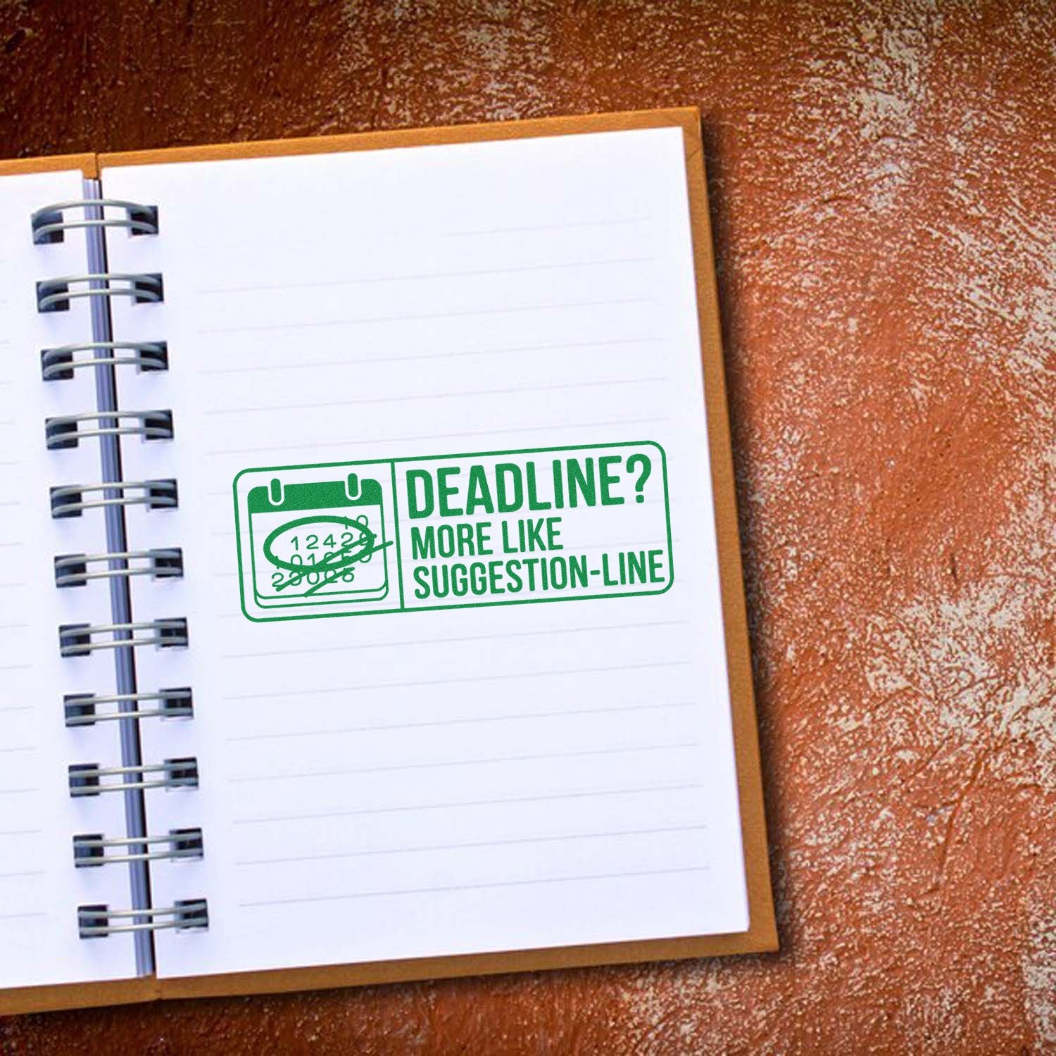 Green rubber stamp seal on a white notebook page reads Deadline? More like suggestion-line with a calendar icon.