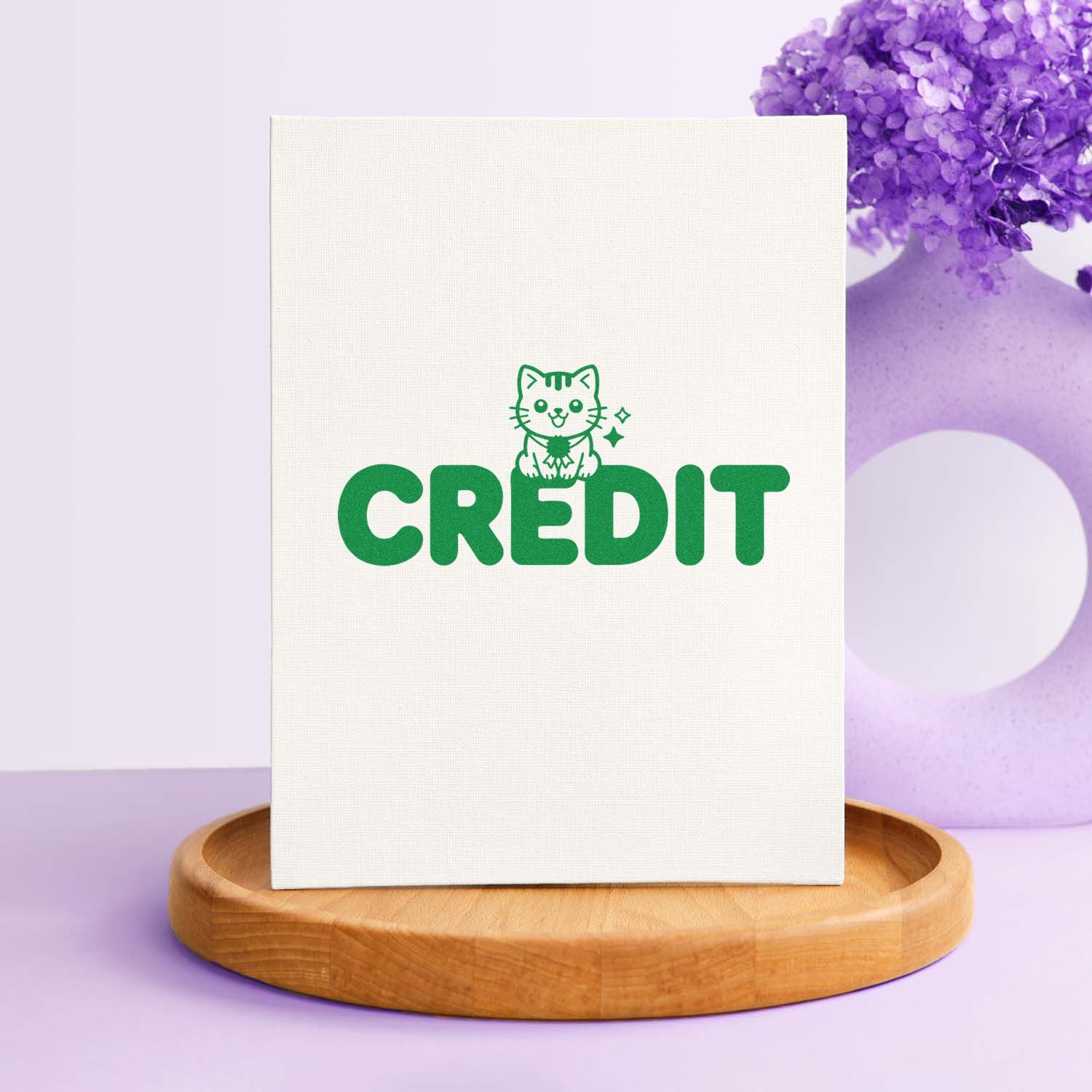 Green CREDIT stamp and seal with cat icon on white canvas, displayed on a wooden base with purple floral accents.