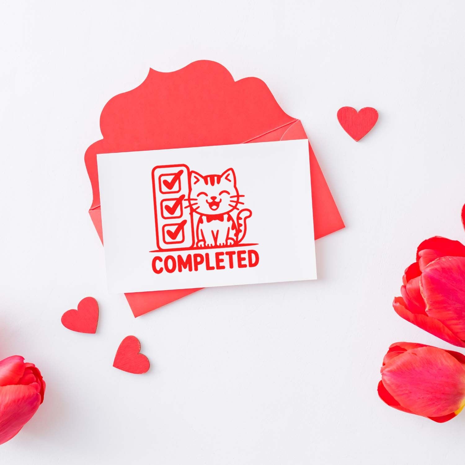 Red rubber stamp seal reading COMPLETED with a cat and checklist on white card, surrounded by hearts and petals.