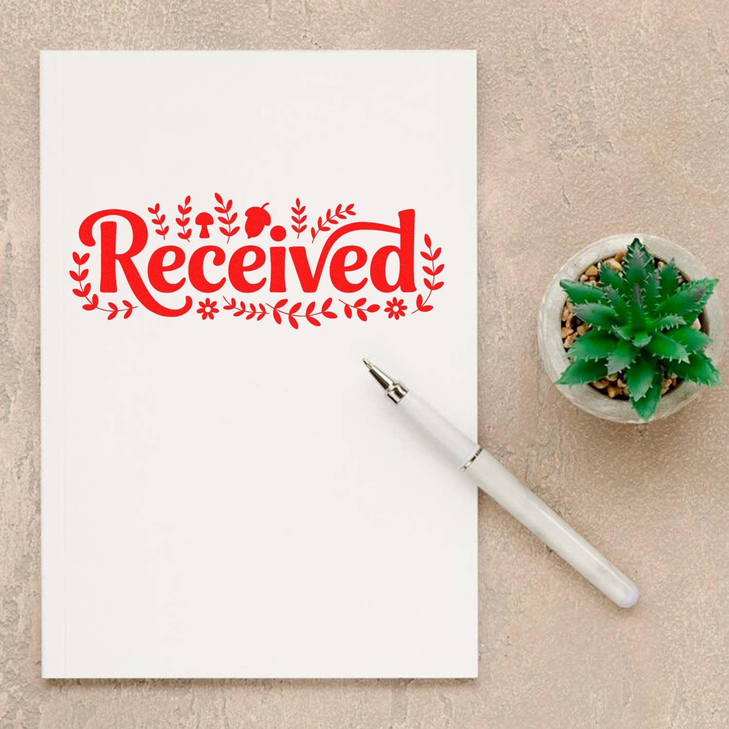 Red floral Received stamp on white paper with white pen and green succulent, custom stamp and seal product display.