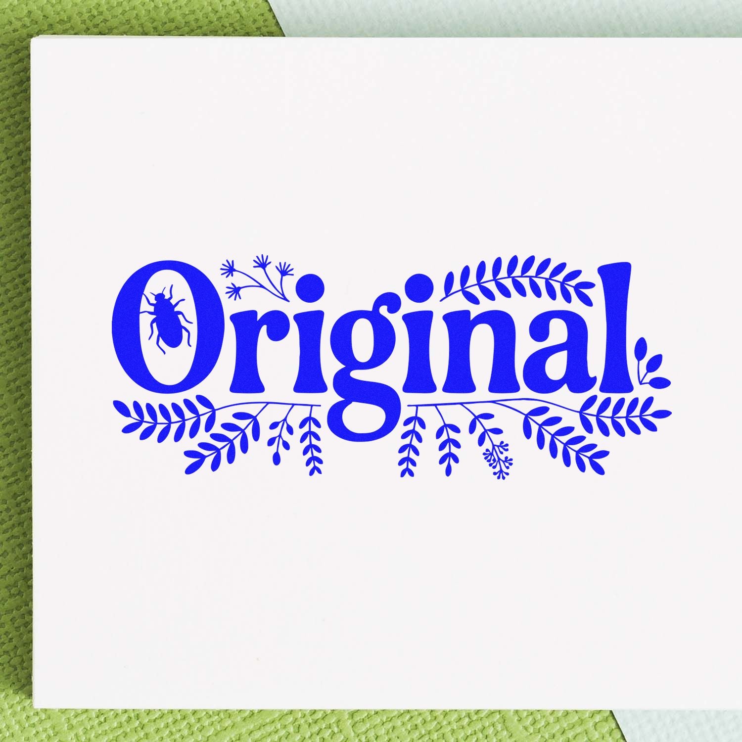 Blue Original decorative stamp seal on white card, with bug in the O and leafy flourishes, on a green textured background.