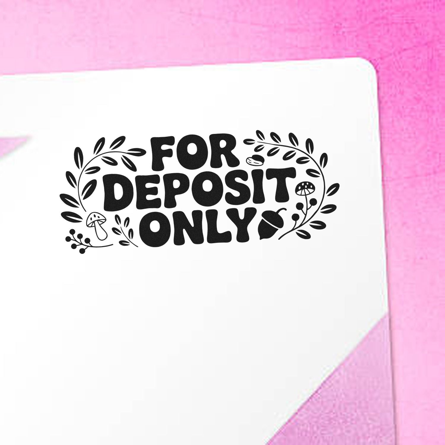 Black FOR DEPOSIT ONLY stamp seal with leaf accents on white paper, against a pink background.