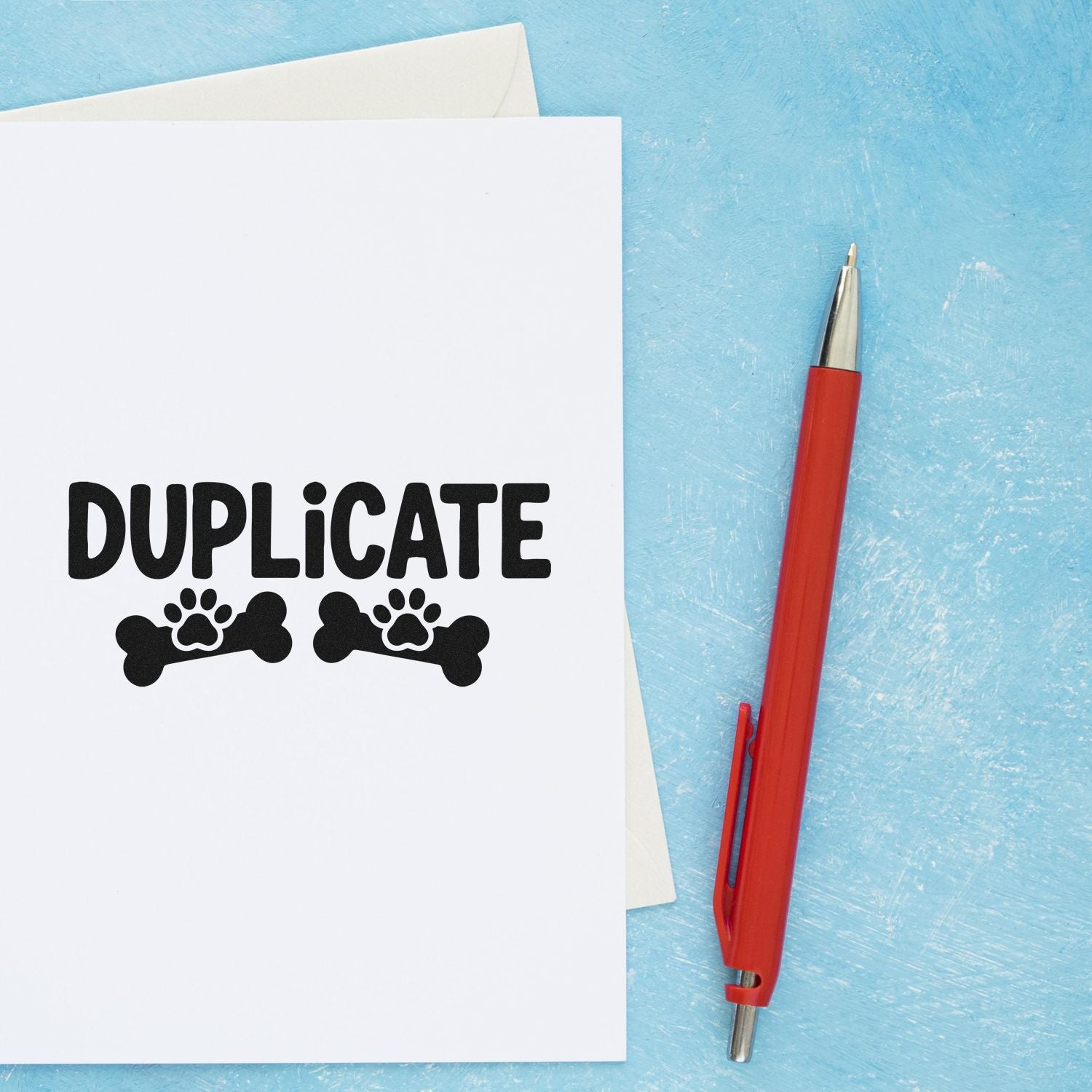 White duplicate stamp sheet with black paw-and-bone seal icons, beside a red pen on a blue background.