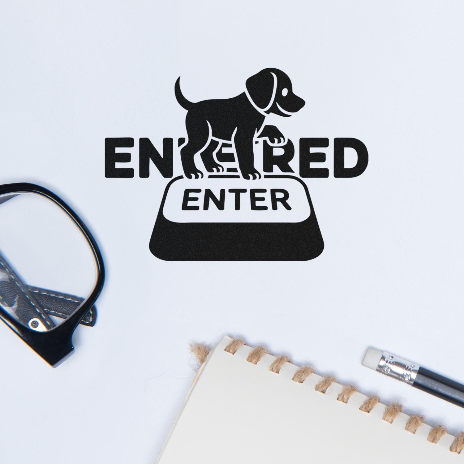Black ENTERED stamp seal with dog icon on white background, beside notebook, pencil, and paper.