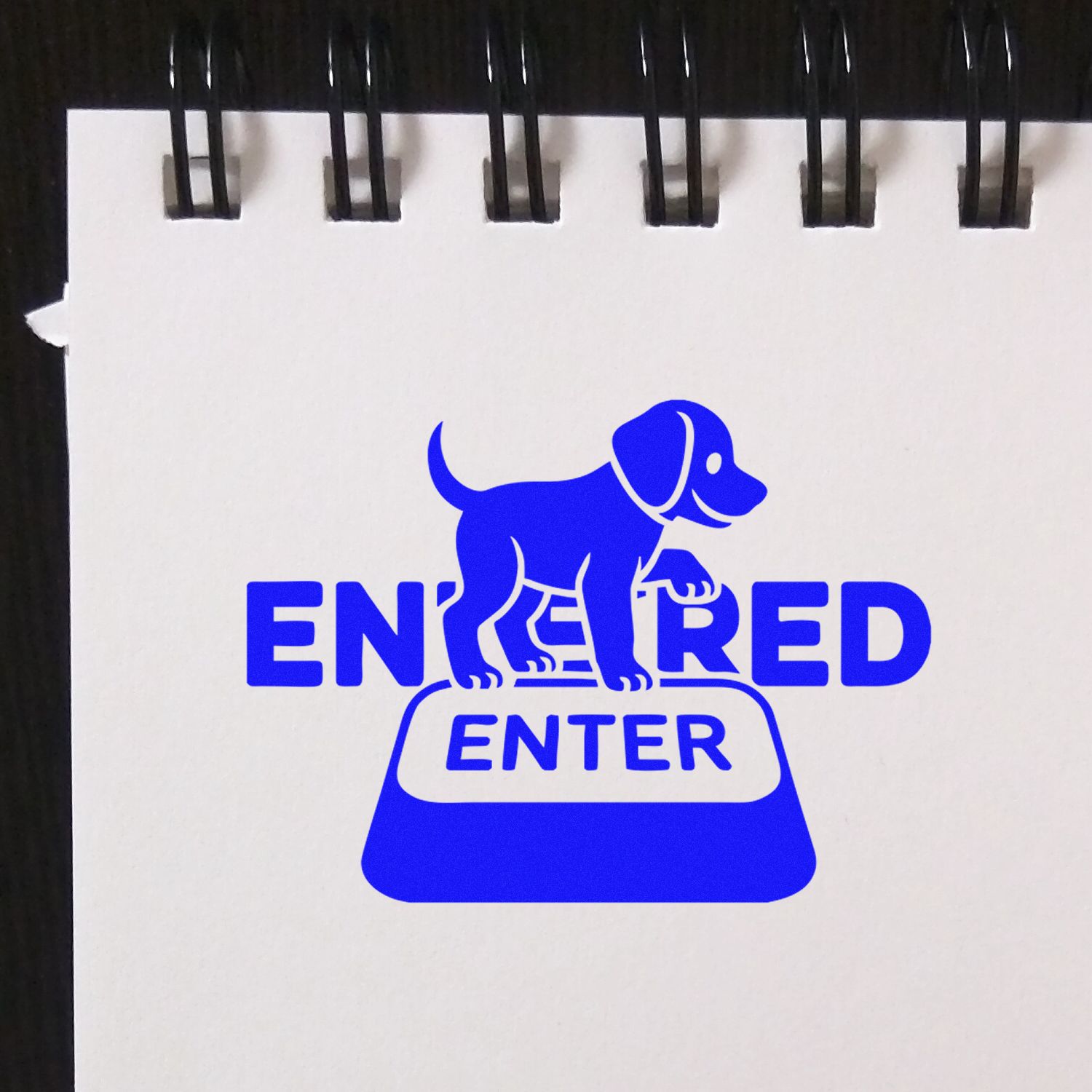 Blue ENTERED stamp with dog above ENTER seal on a white spiral notebook page.