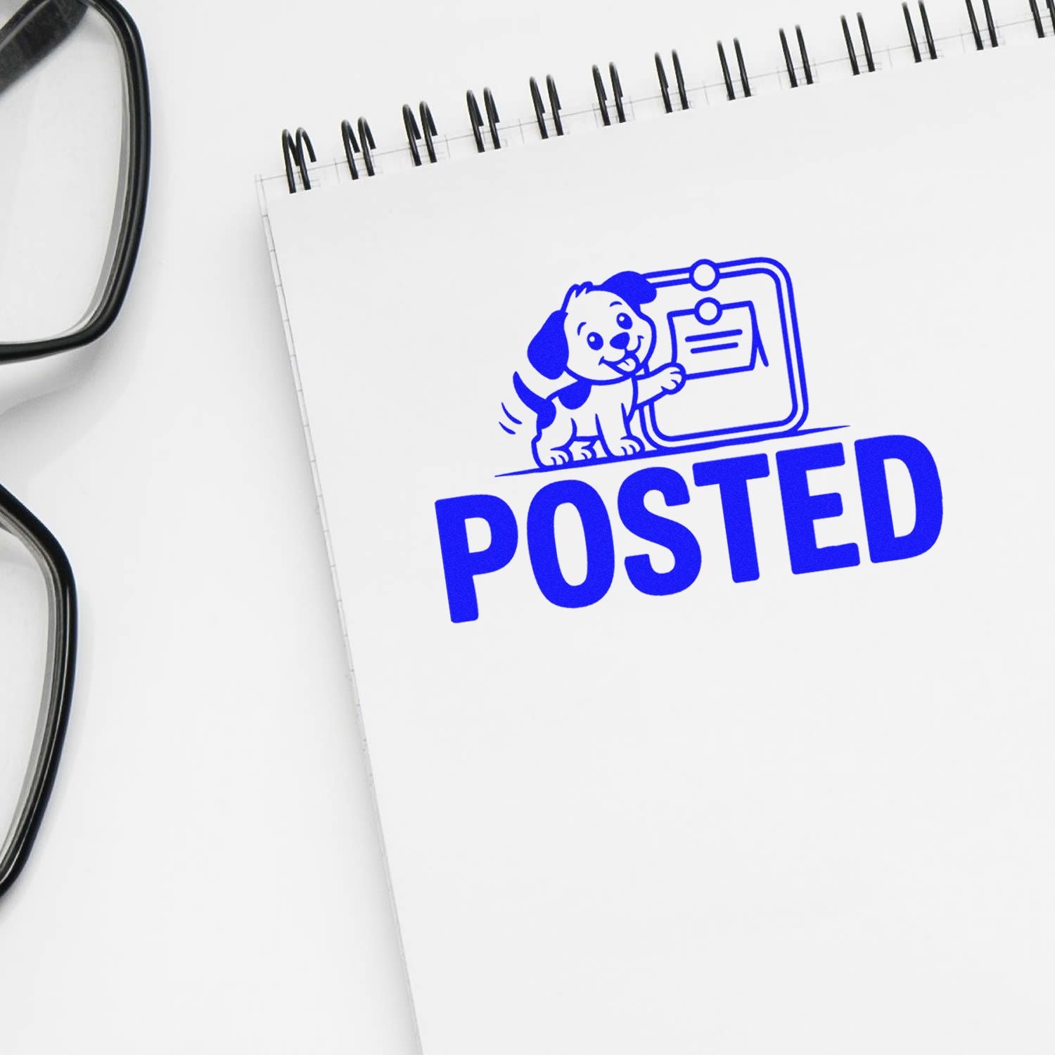 Blue POSTED stamp with dog logo on a white notepad beside black eyeglasses, showcasing stamp and seal products