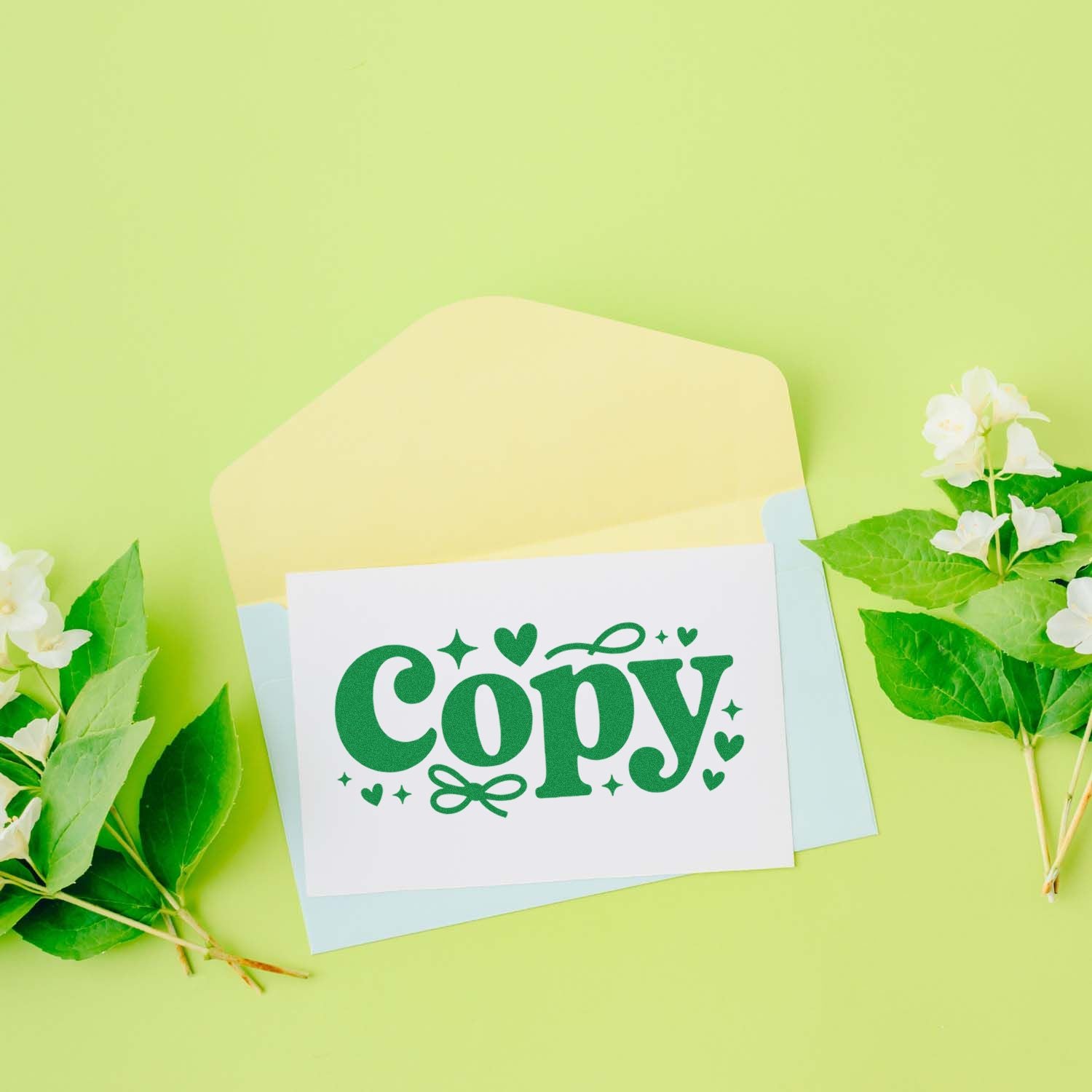 Green Copy rubber stamp seal on white card with pastel envelopes, on a light green background with white flowers and leaves.