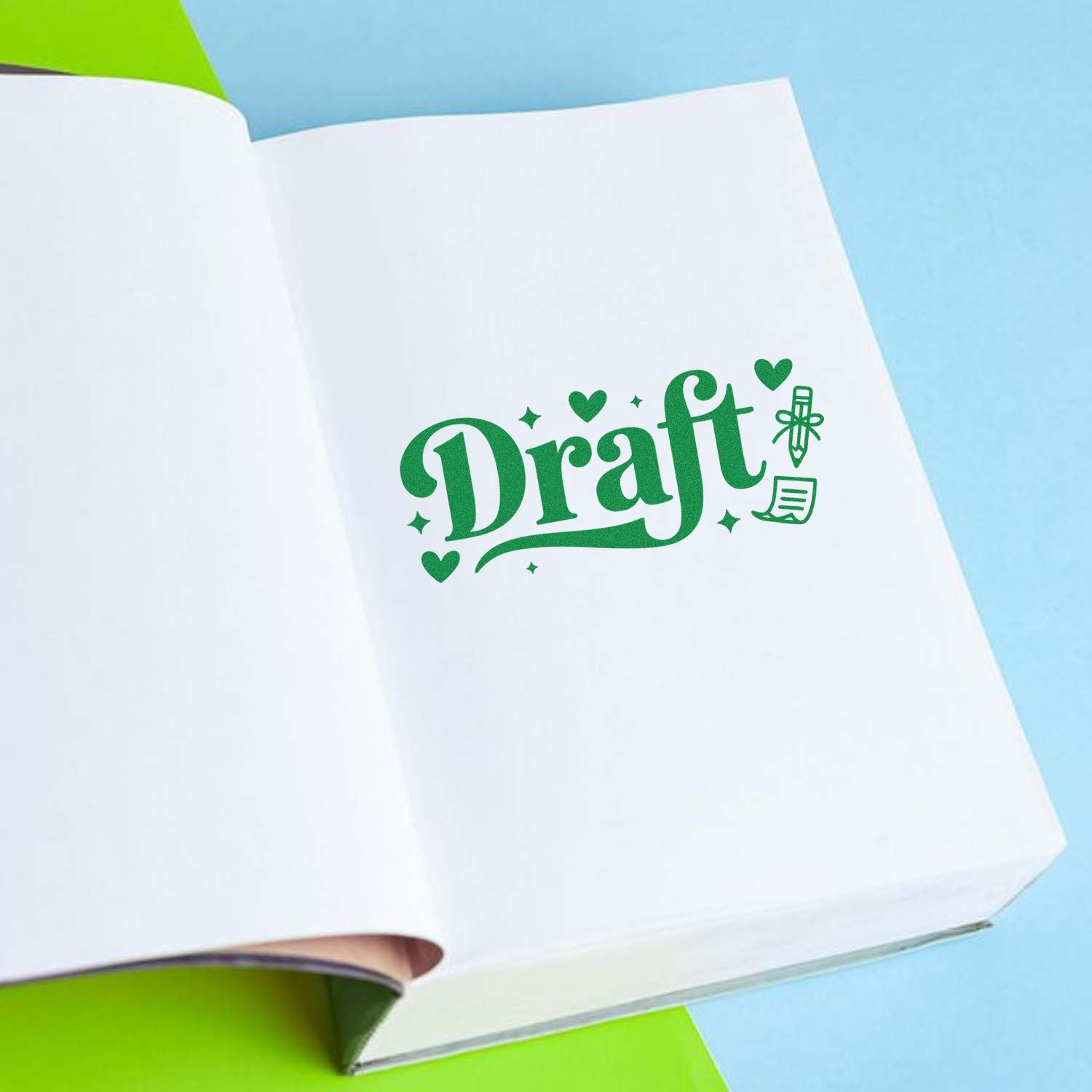 Open white notebook with green Draft stamp and seal design, hearts, sparkles, pen and note icons on blue background.