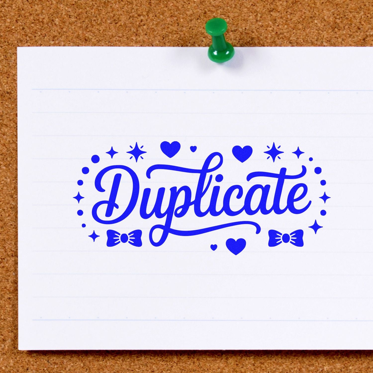 Blue Duplicate stamp seal with hearts and bows on white lined paper, pinned to a corkboard with a green pushpin.