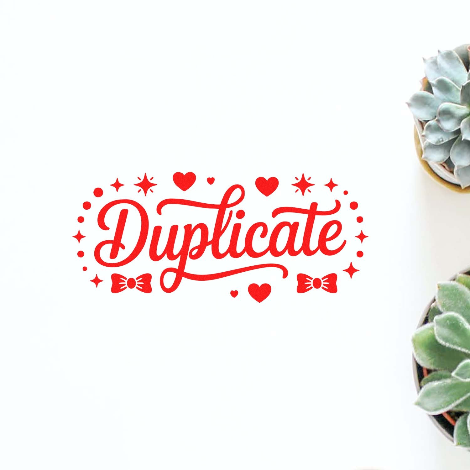 Red Duplicate stamp seal with hearts, stars and bows on a white background beside succulents