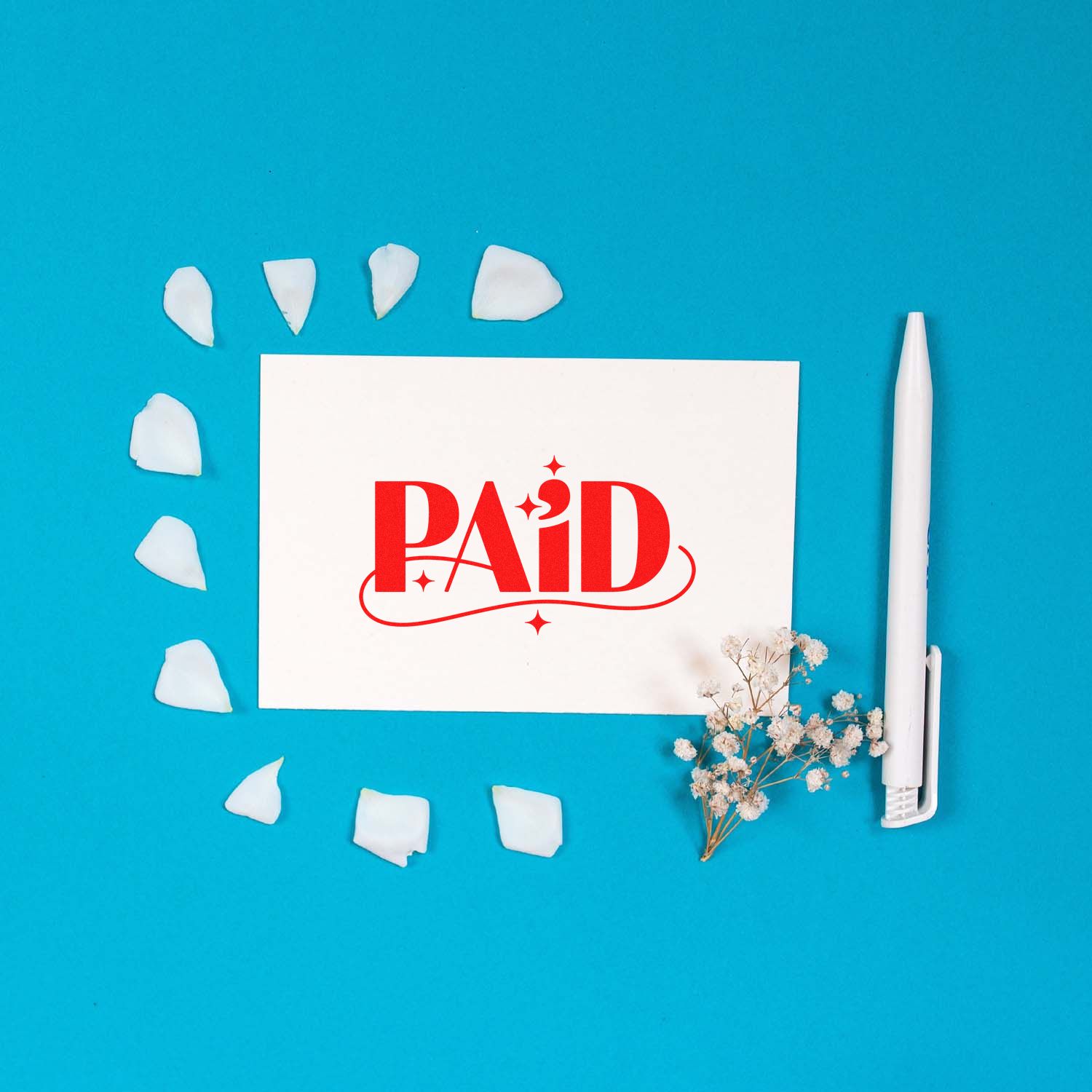 Red PAID stamp on white card with wax seal pieces, white pen, and dried flowers on a bright blue background.