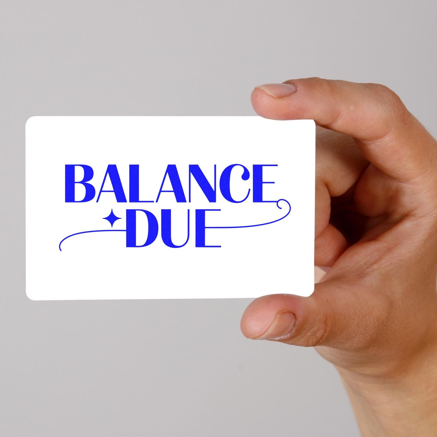 Hand holding a white stamp card with bold blue BALANCE DUE lettering and decorative seal flourishes.