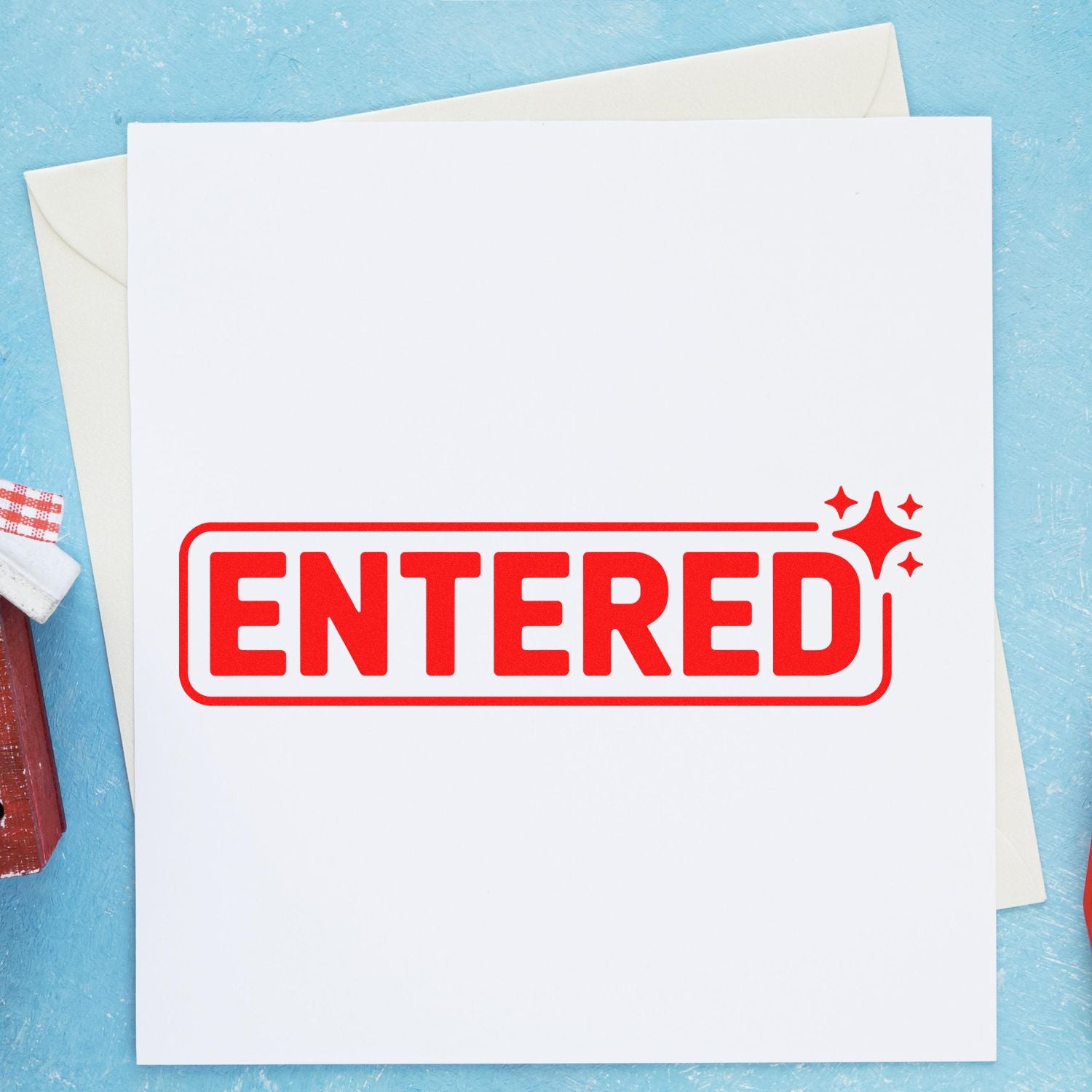 Red ENTERED rubber stamp seal on white paper with sparkle marks, over blue background.