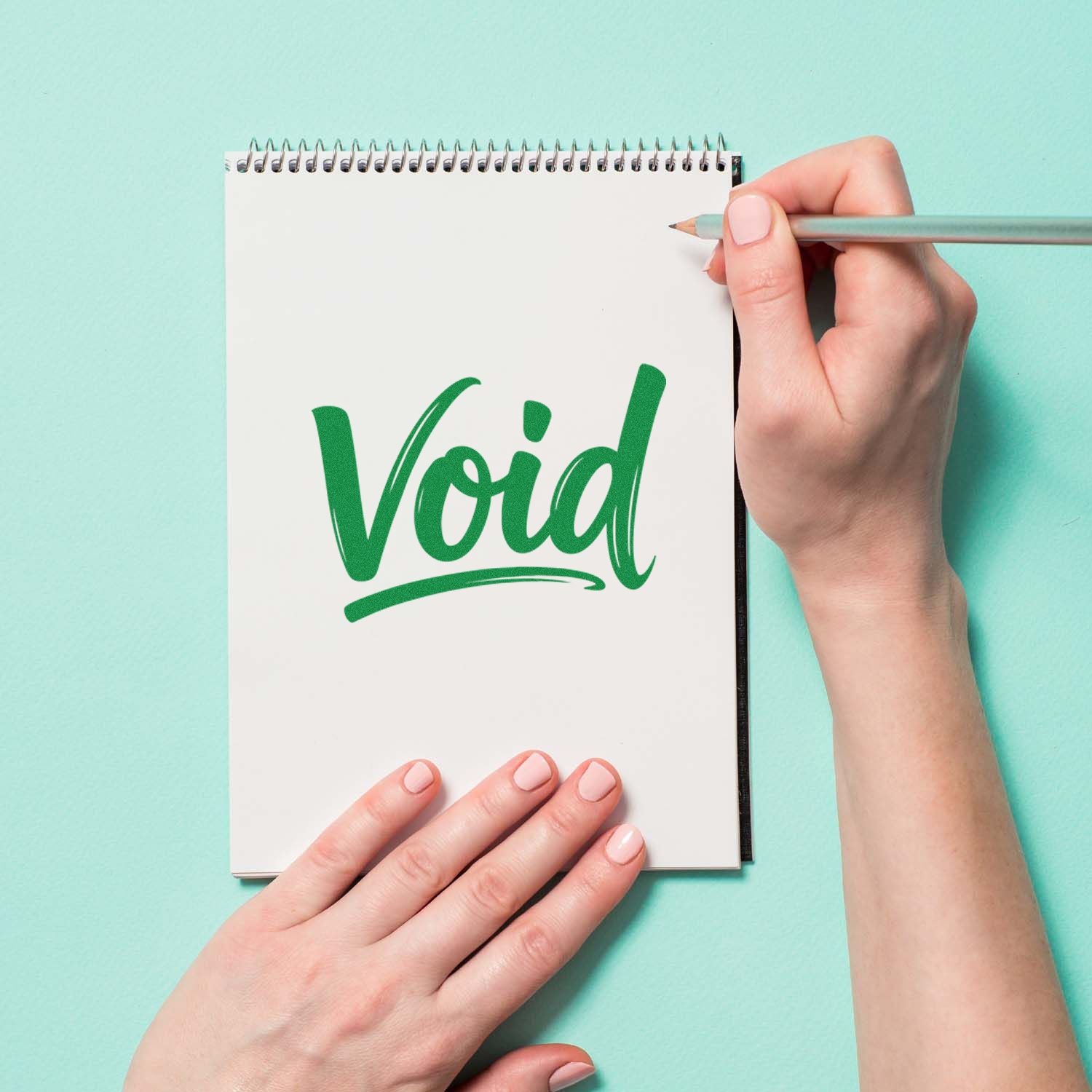 Green VOID stamp seal on white spiral notebook, held by hands with pencil on mint background.
