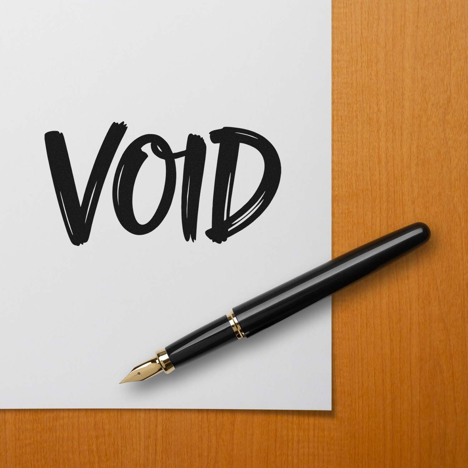 Black fountain pen with bold VOID stamp on white paper, set on a warm wood desk.