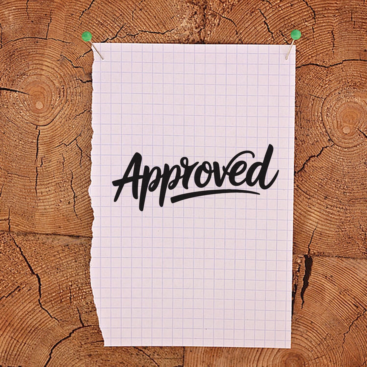 Black Approved stamp on white graph paper pinned to rustic wood background, showcasing stamp and seal products.