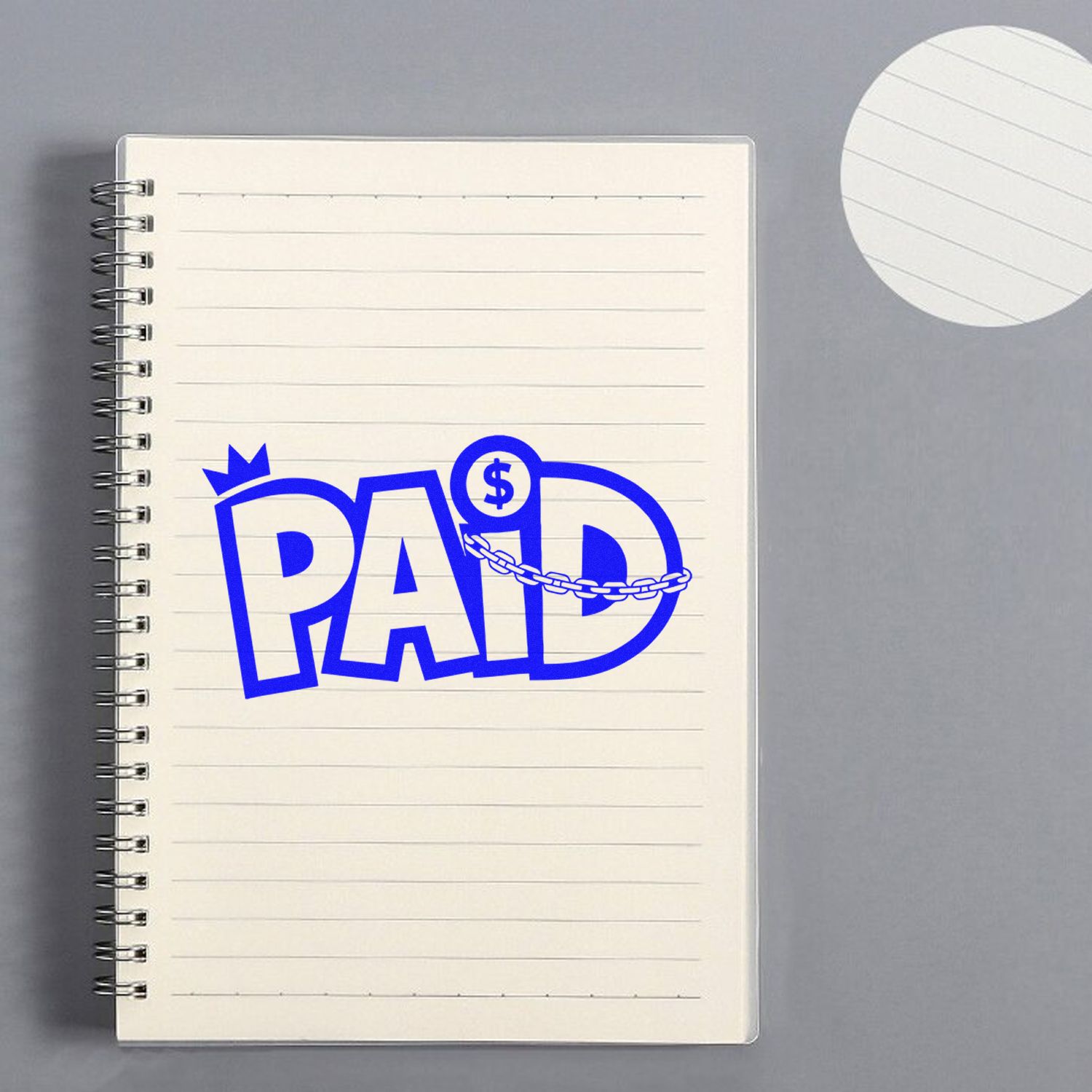 Blue PAID stamp and seal on cream spiral notebook, with dollar sign and chain graphic