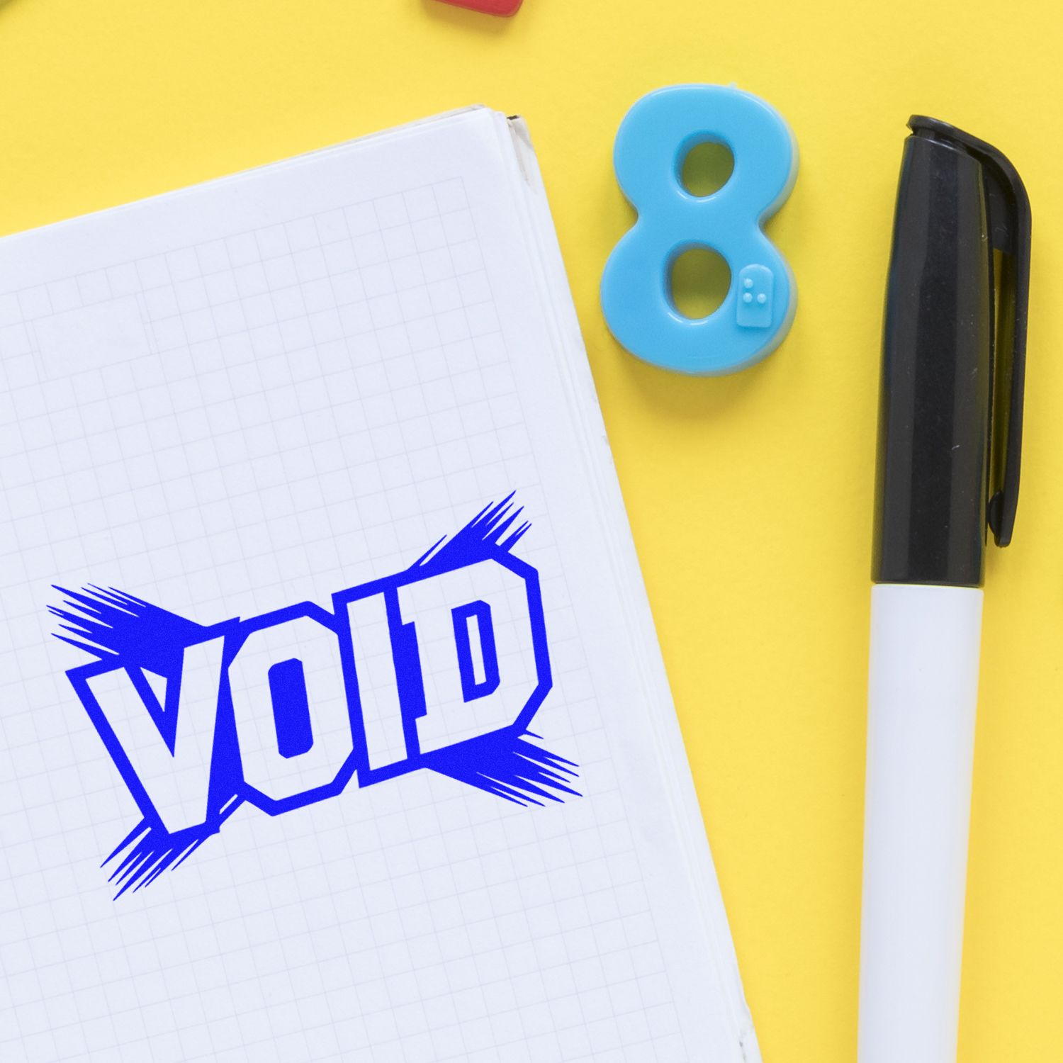 Blue VOP stamp impression on a white notebook, with an 8-shaped seal and black pen on a bright yellow background.