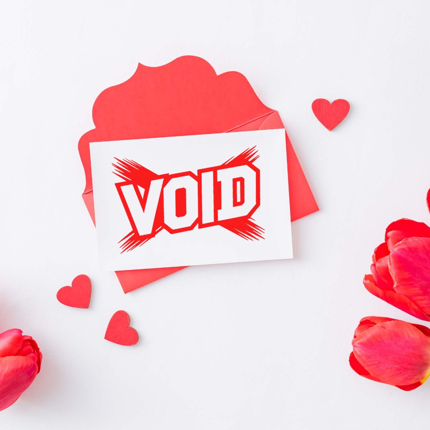 Red VOID stamp seal on white card with pink envelope, paper hearts, and rose petals