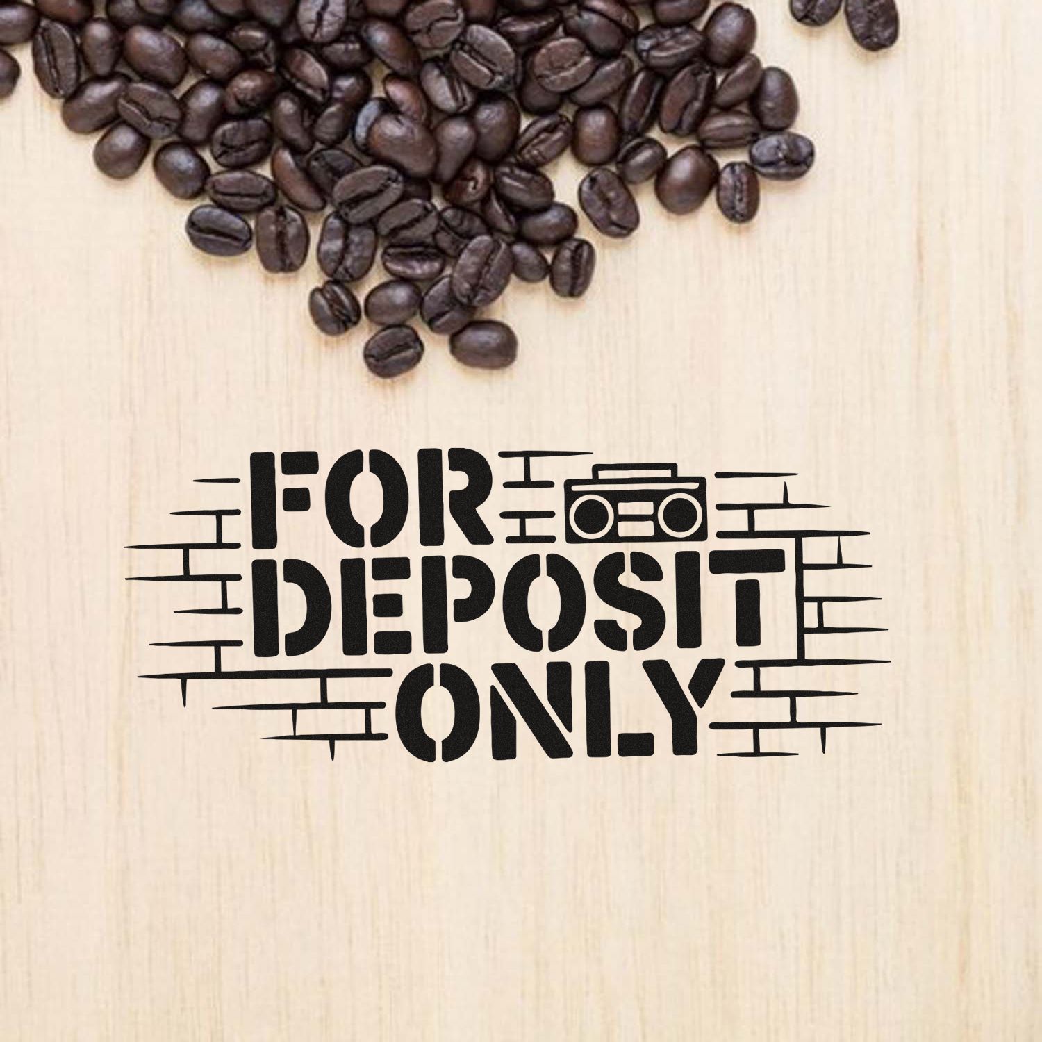 Black FOR DEPOSIT ONLY stamp and seal on light wood, with coffee beans above.