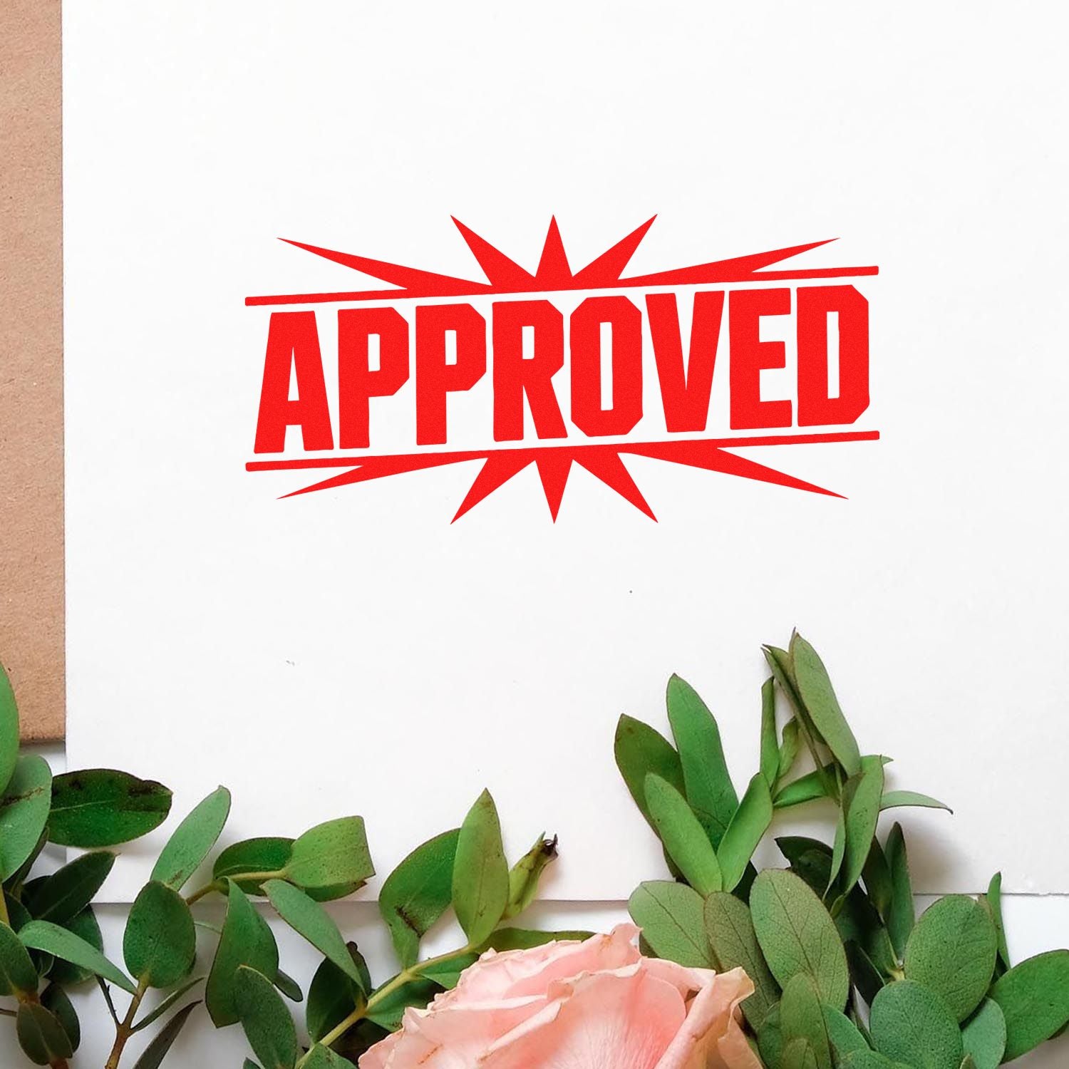 Red APPROVED stamp seal on white paper, framed by green leaves and a pink rose