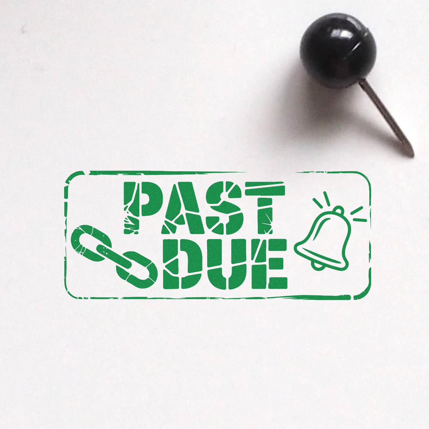 Green PAST DUE rubber stamp seal with chain and bell icons, beside a black pushpin on white paper.