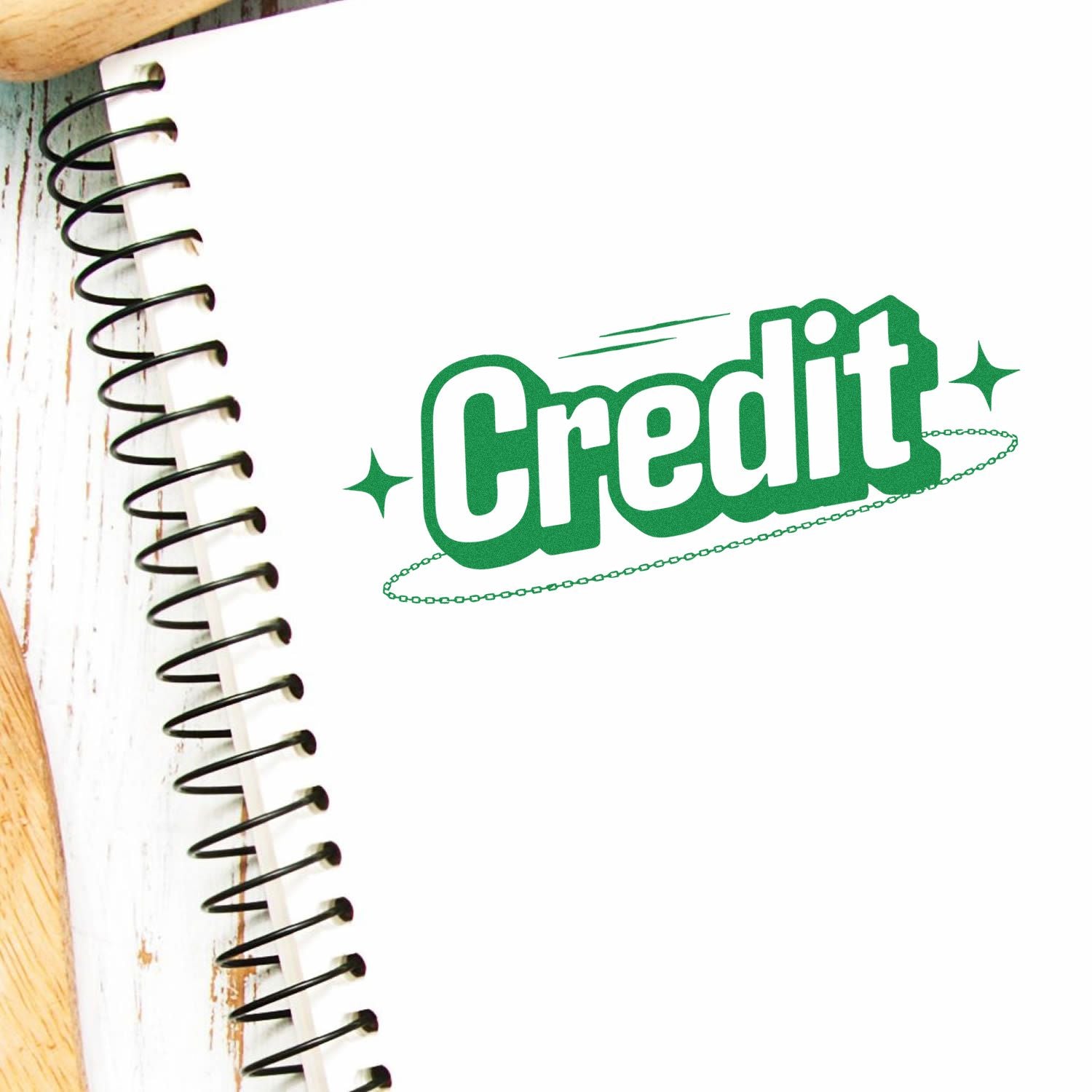Green Credit stamp seal with sparkles on white background beside a notebook spiral binding.
