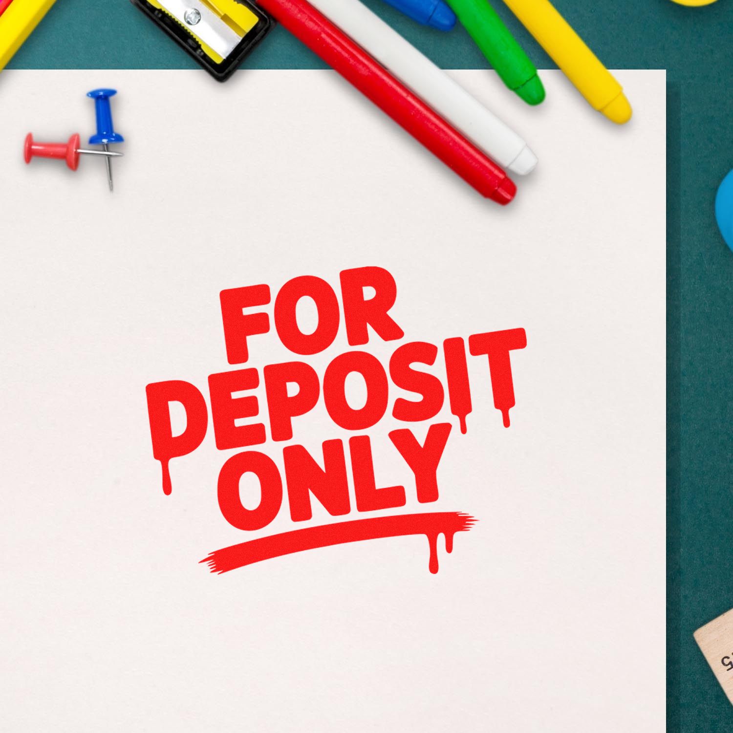 Red FOR DEPOSIT ONLY stamp on white paper, with colorful stamp and seal products, pens, and push pins