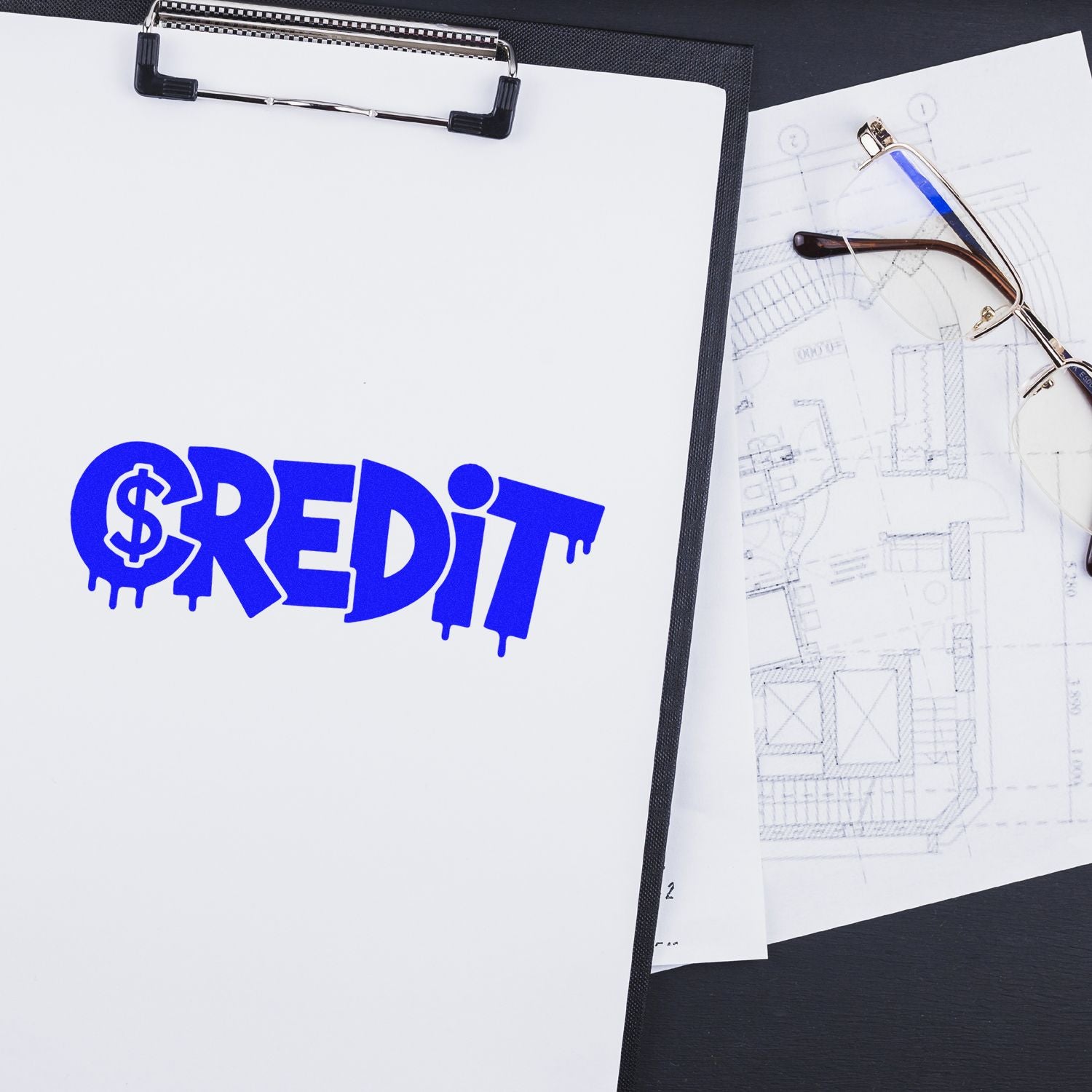 Blue CREDIT stamp-and-seal logo on a white clipboard, beside eyeglasses and blueprint sketches.