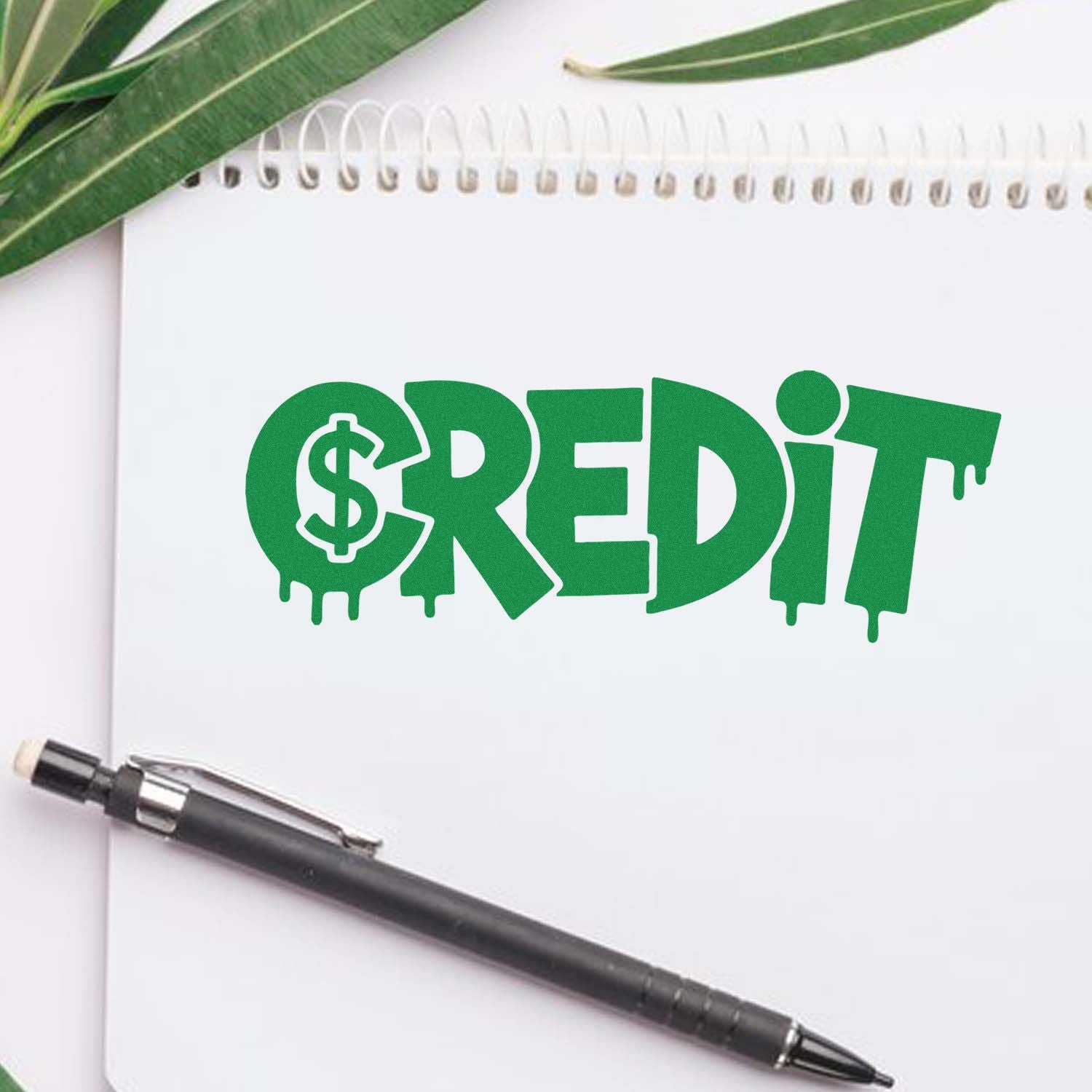 Green CREDIT stamp design with dollar sign on white notebook, beside pen and leaves, for stamp and seal products.
