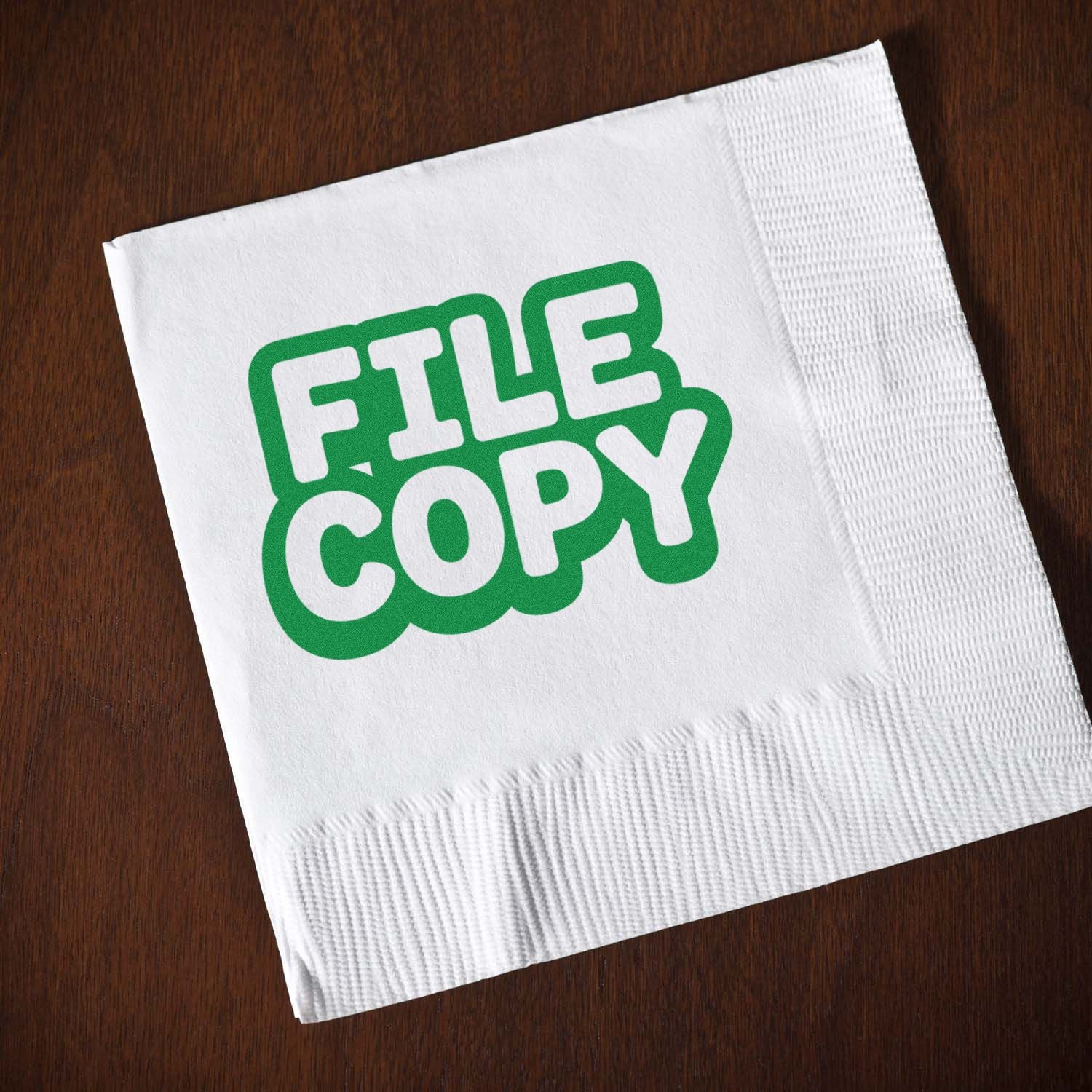 White napkin with green FILE COPY stamp seal on dark wood background