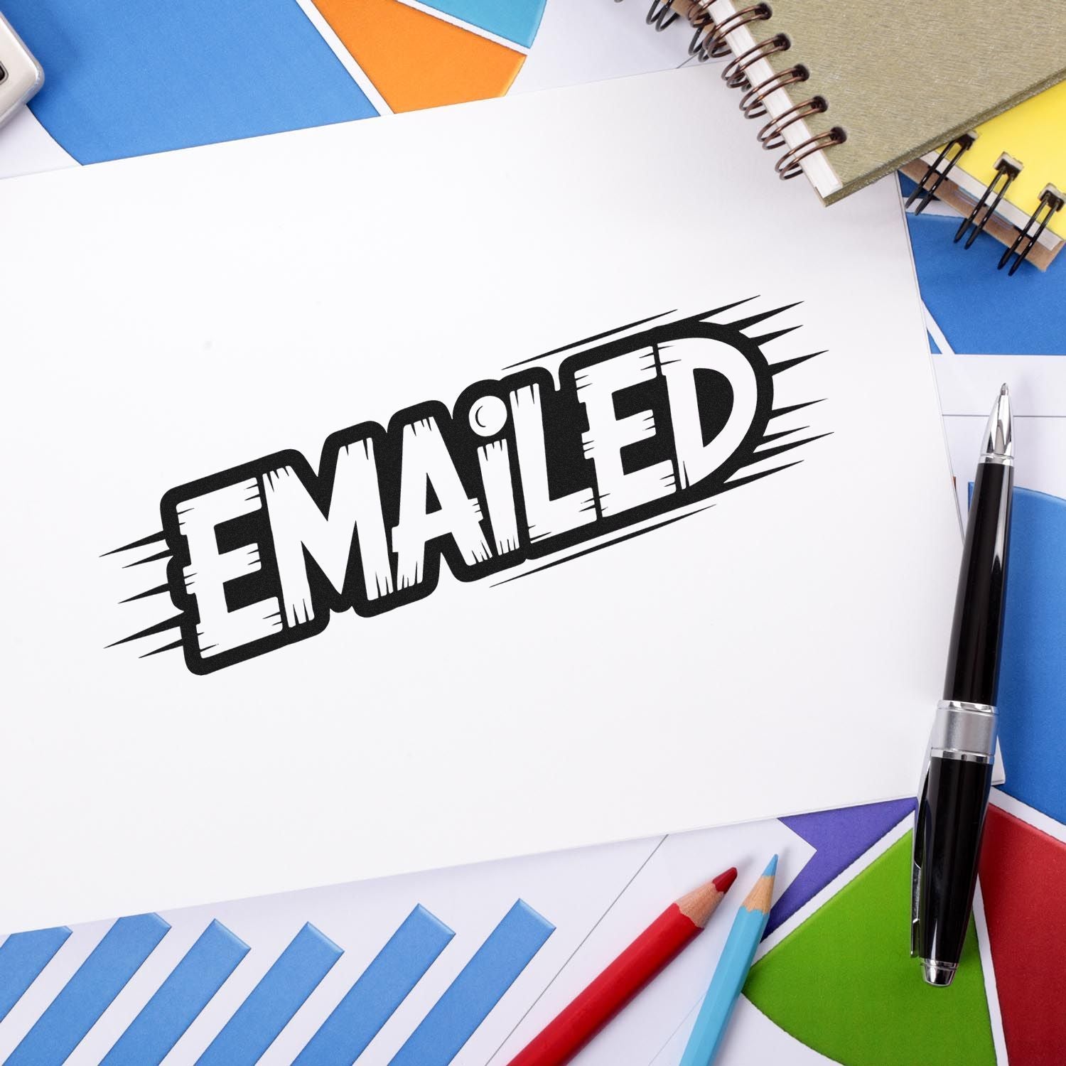 Black EMAILED rubber stamp and seal impression on white paper, with blue, orange, yellow stationery and pens.