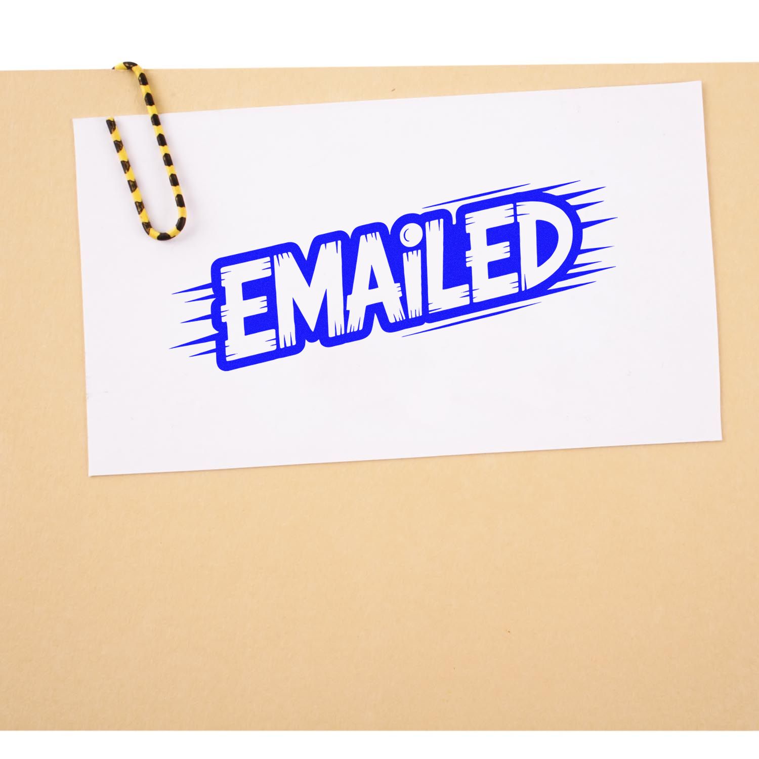 Blue EMAILED stamp seal on white card, clipped with a yellow-and-black striped paperclip against tan background.
