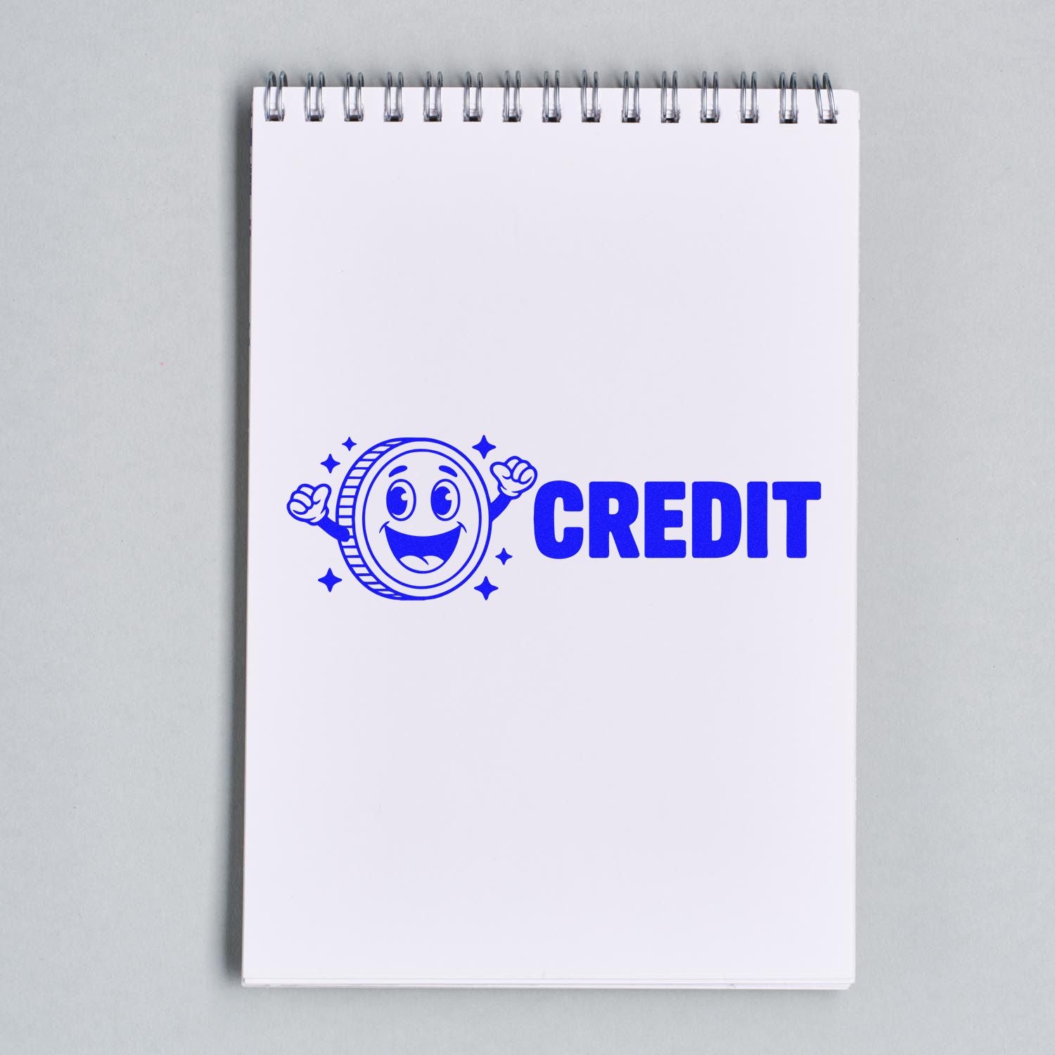 Blue credit stamp and seal on white spiral notebook, featuring a smiling coin mascot.