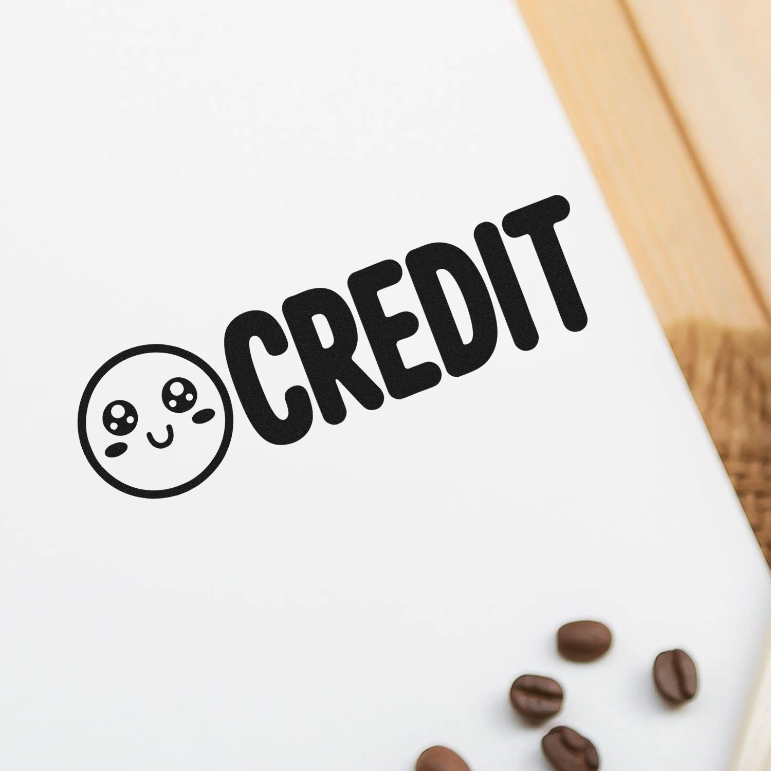 Black CREDIT stamp and cute seal product on white paper, with coffee beans and light wood background.