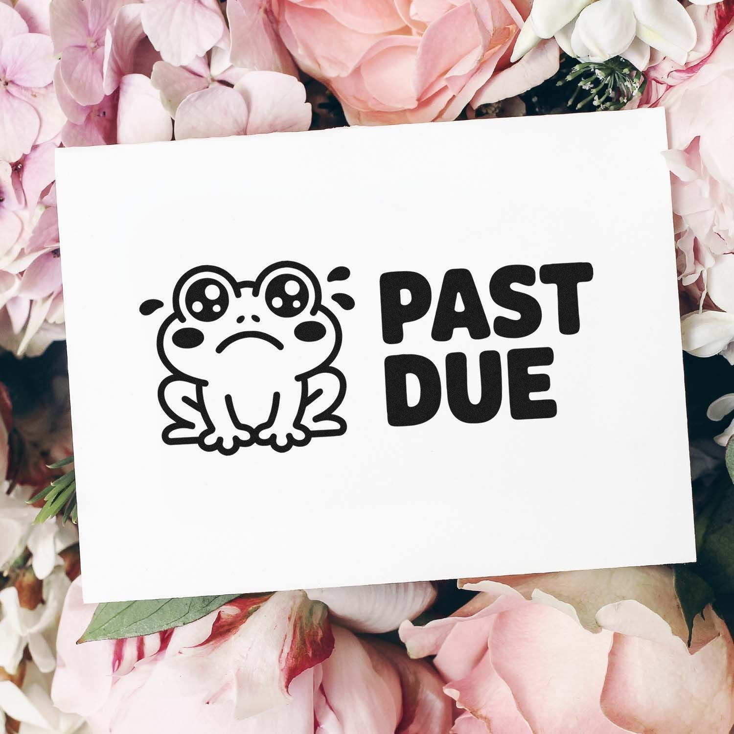 Black frog PAST DUE rubber stamp seal on white card, surrounded by soft pink flowers.