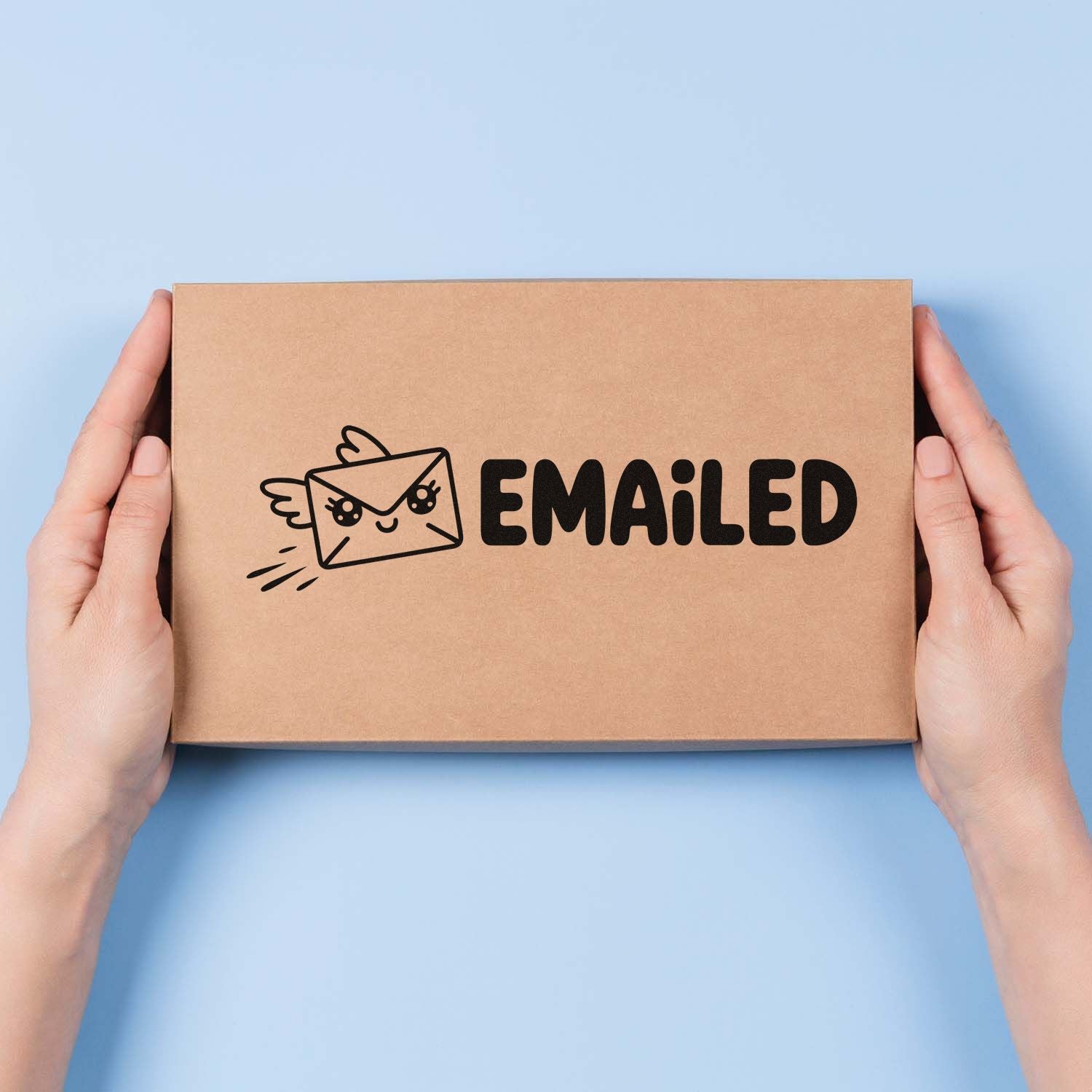 Hands holding kraft box with black EMAILED mail stamp and cute envelope seal on a light blue background.