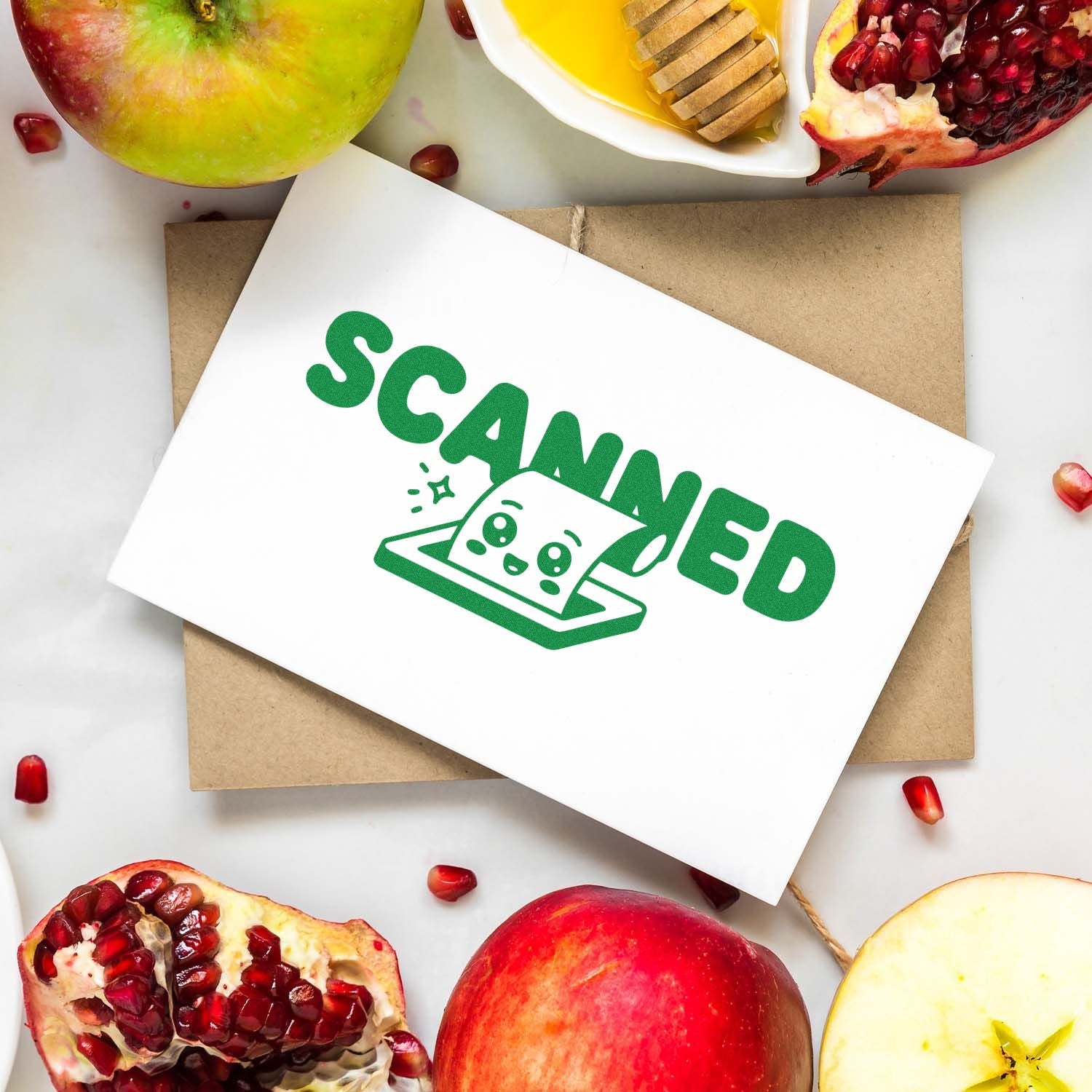 Green SCANNED custom stamp and seal on white card over kraft envelope, framed by pomegranates and apples.