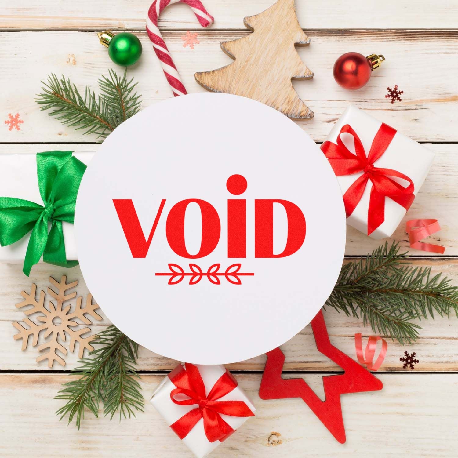 Round white seal stamp with red void text, surrounded by Christmas gift boxes, pine branches, ornaments, and wooden decorations.