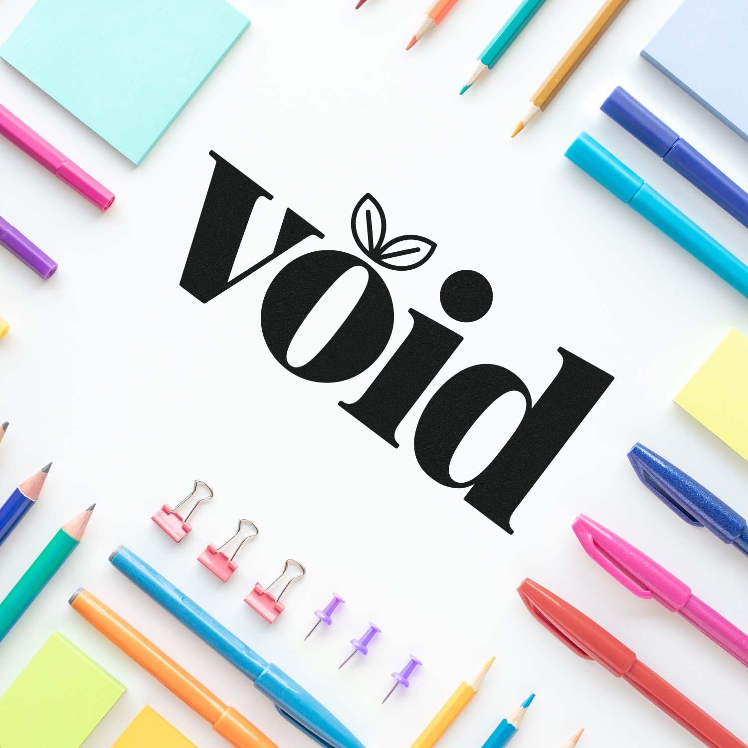 Black VOID stamp and seal logo centered on white, surrounded by colorful pens, pencils, sticky notes, and binder clips.