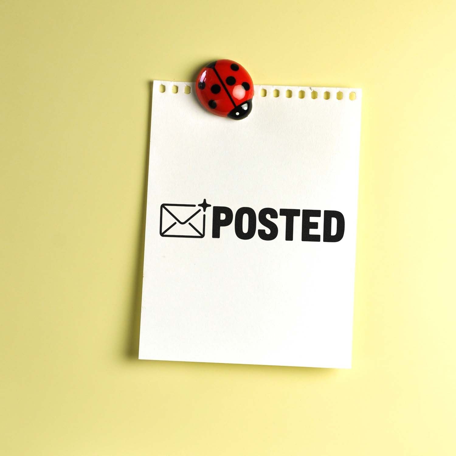 Red ladybug seal stamp on a white POSTED note with black envelope icon, against a pale yellow background.