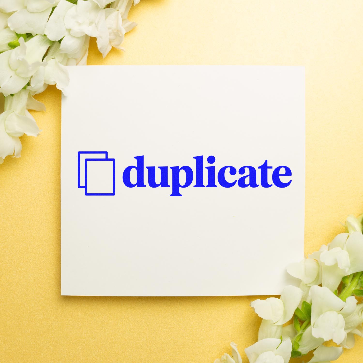 Blue duplicate stamp and seal on white card, with white flowers on a soft yellow background