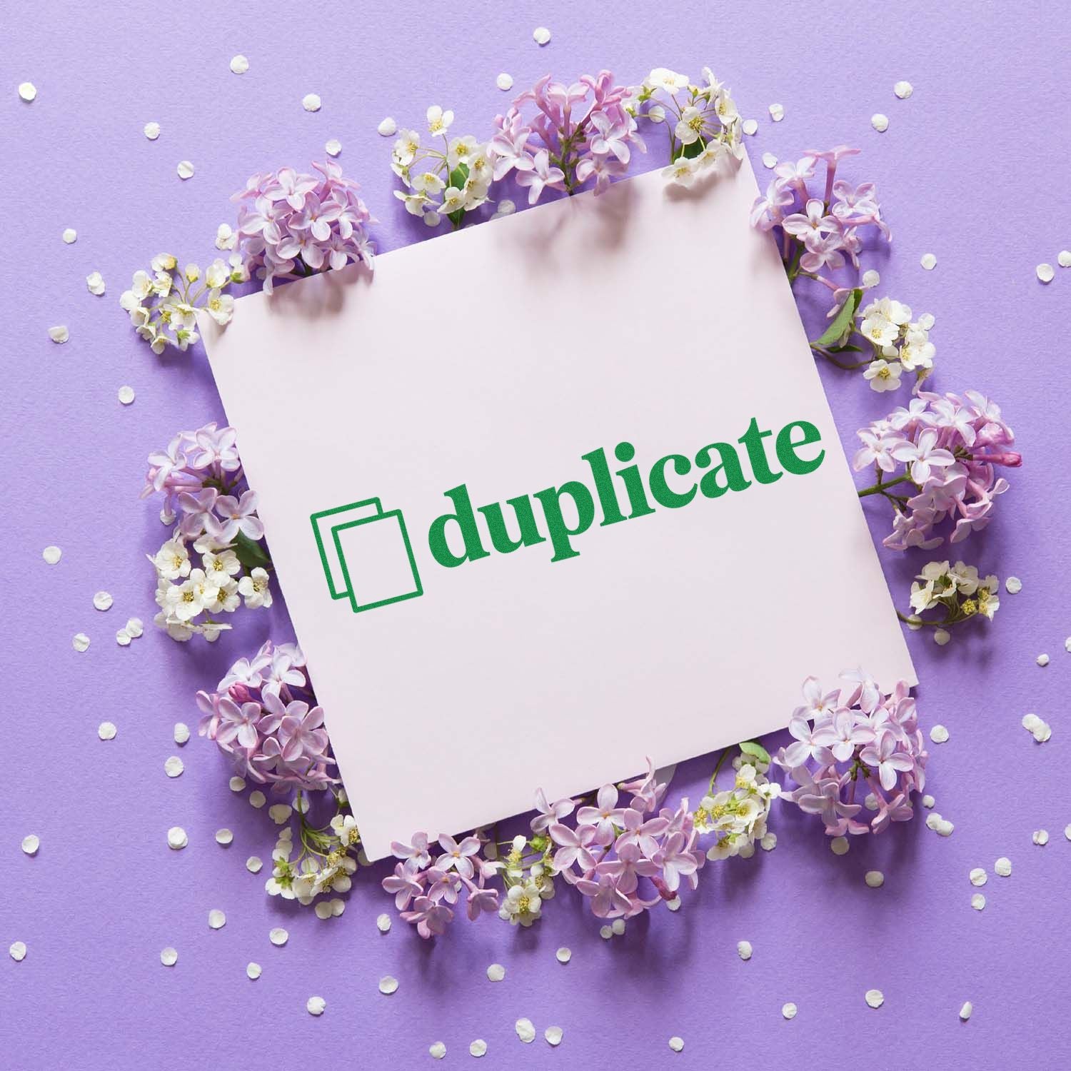White duplicate stamp seal on pale pink card, surrounded by lavender blossoms on a purple background.
