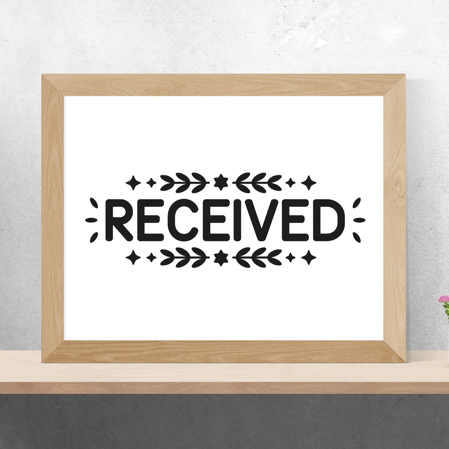 Wooden-framed white print with black RECEIVED stamp seal, decorated with stars and leaf motifs.