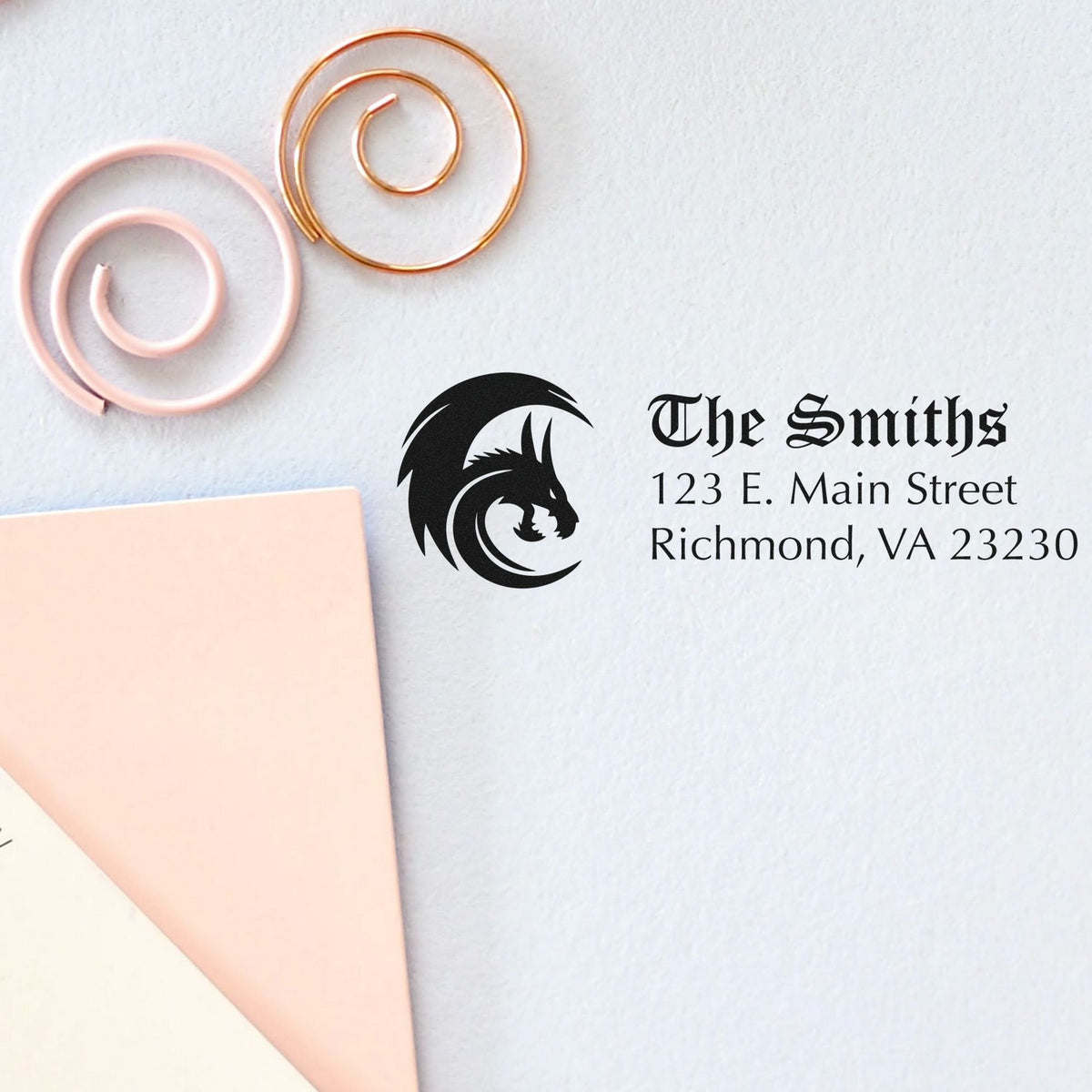Custom stamp and seal set with black dragon logo, The Smiths address, and copper and blush wax seal tools on white paper.