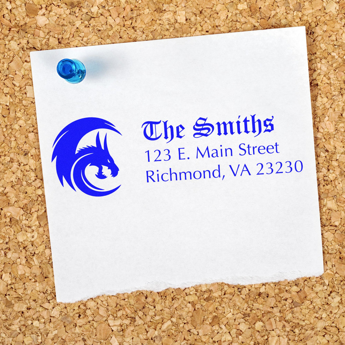 Blue custom address stamp and seal on white paper pinned to corkboard, featuring a wolf logo and The Smiths, Richmond VA.