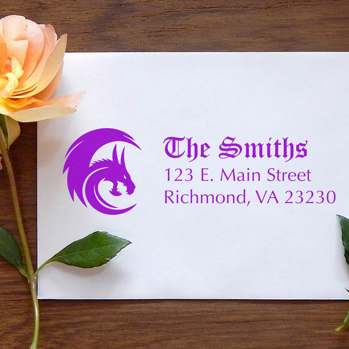 Purple custom stamp and seal for The Smiths with wolf logo and address on white paper, beside a peach flower.
