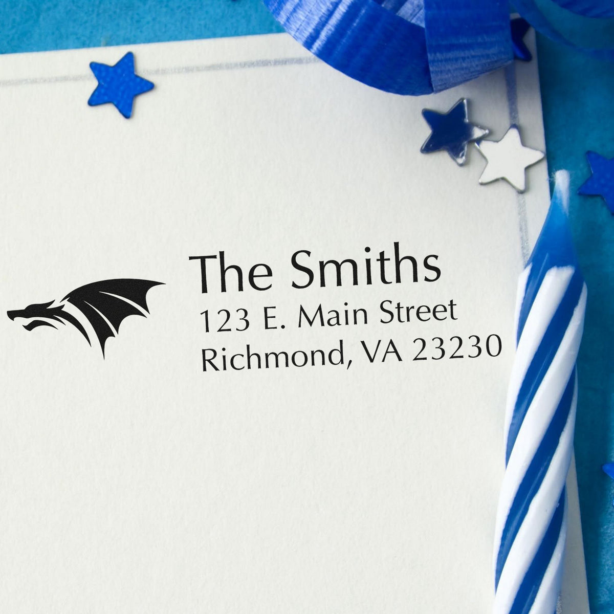 Blue ribbon gift seal on white envelope with star-shaped stamp seals, black dragon logo, and The Smiths address.