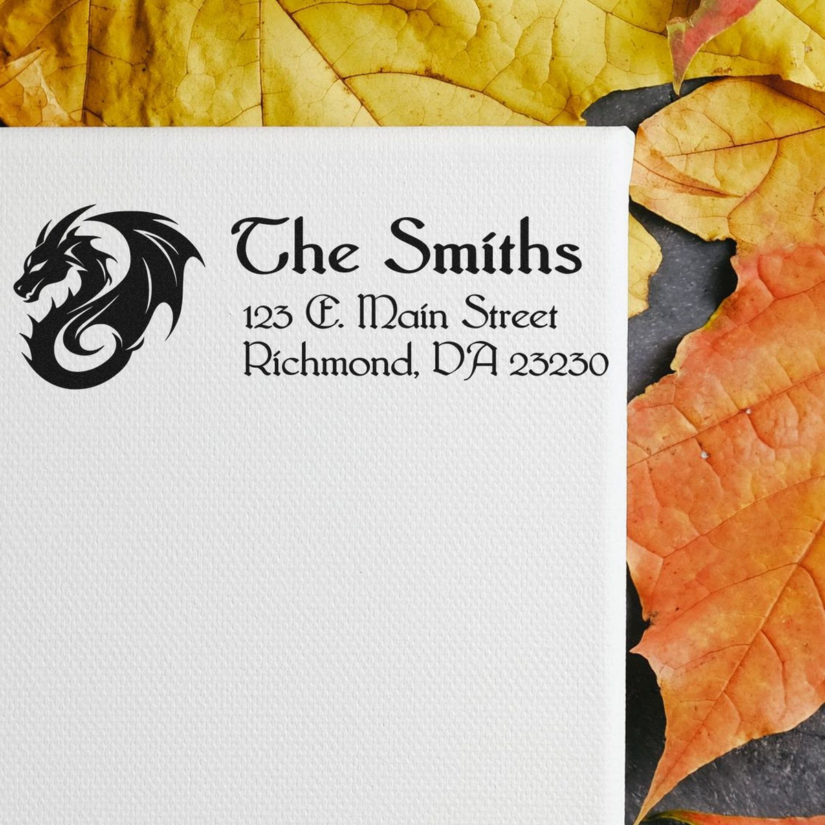 Custom business stamp and seal with black dragon logo and The Smiths on textured white card, framed by yellow-orange leaves.